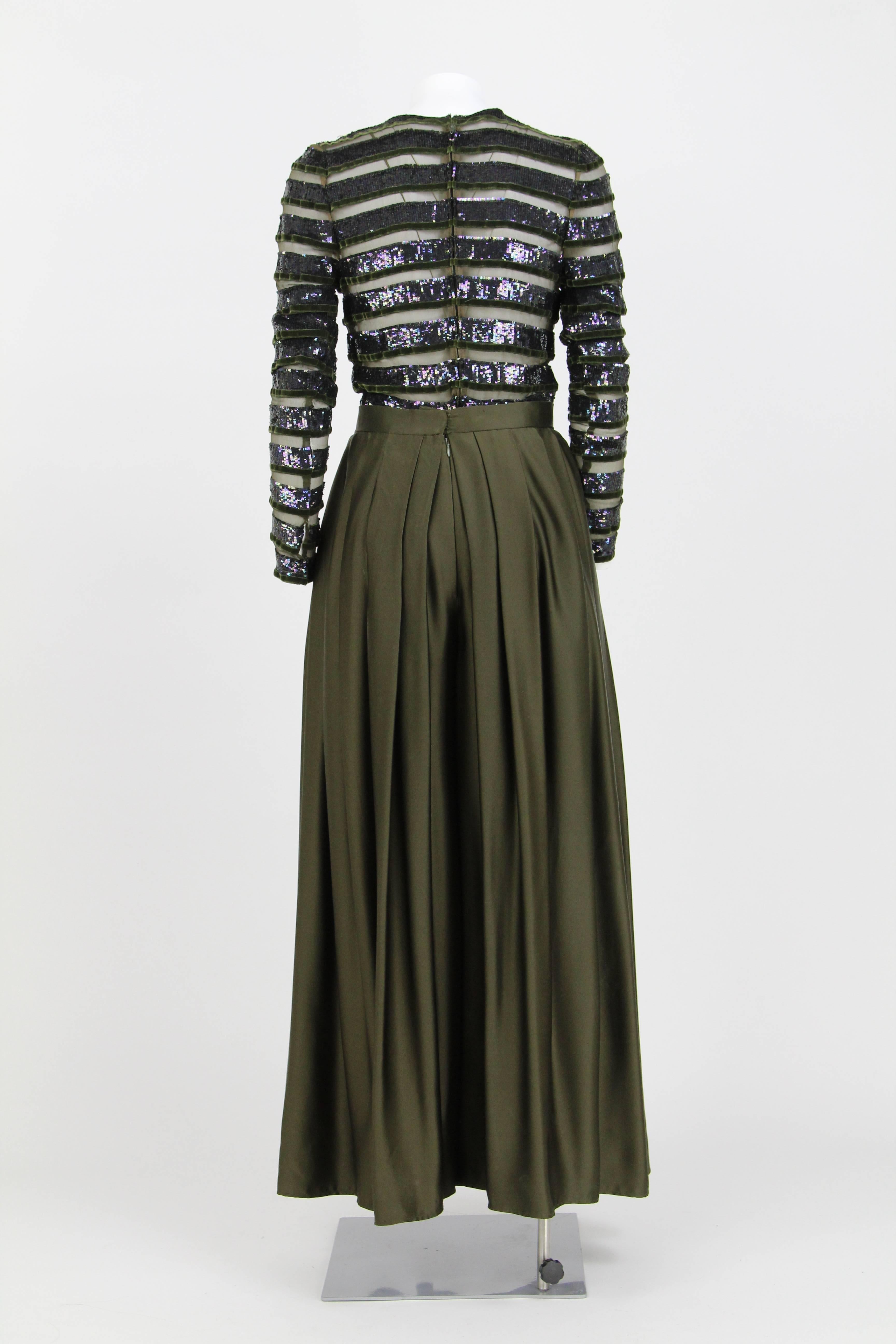 Oscar De La Renta dark green suit composed by top and trousers. Top with sequins, in semi-transparent fabric and velvet. Round neckline and long sleeves. Pleated high-waisted trousers with a wide cut.

Size: 40 IT

Flat measurements
Top
Height: 56