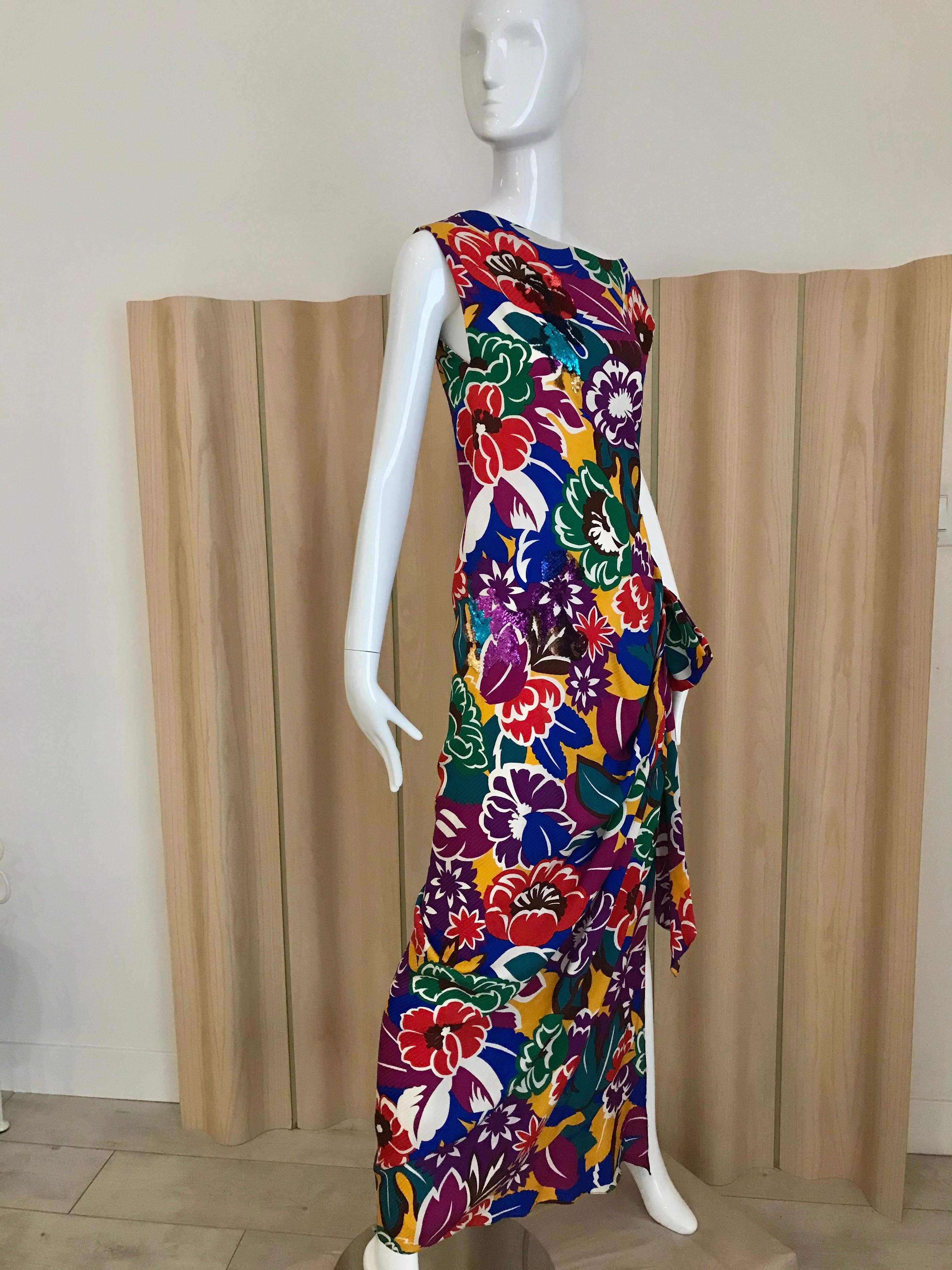 Vintage Oscar De La RENTA Vibrant multi color floral print dress in purple, green , turquoise, orange, blue and magenta silk print dress with sequins and bow. Dress has side slit with bow. 
Size: Medium
Bust: 36 inches/ Waist: 30 inches/ Dress