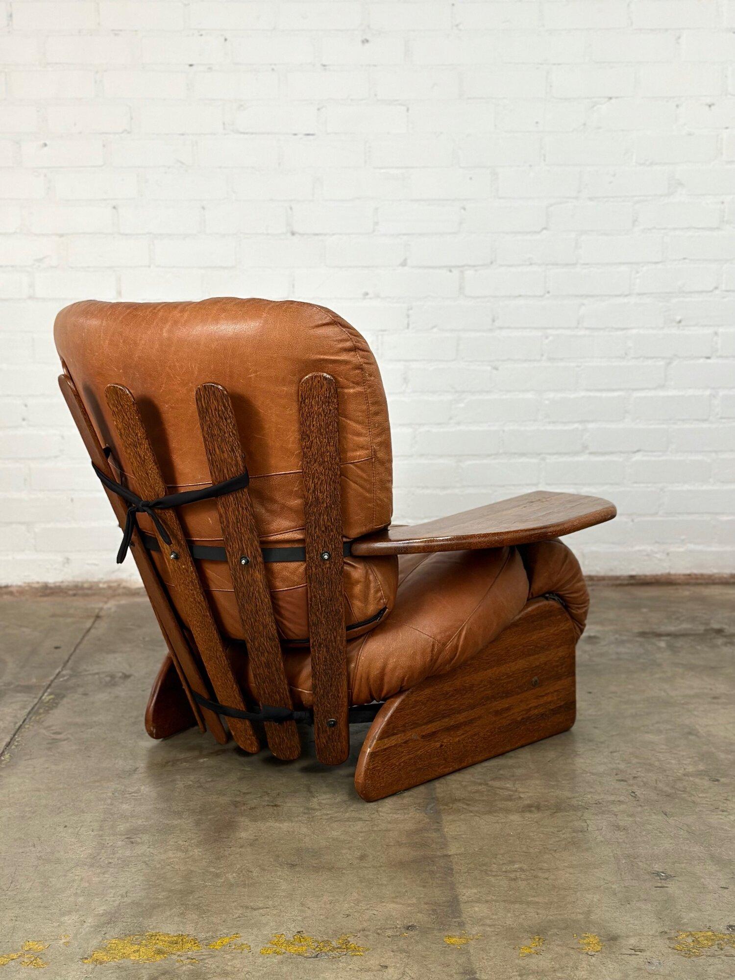 Measures: W42 D36 H37 SW24 SD22 SH16 AH21

Vintage lounge chair made in palm wood, constructed with metal to hold the shape of the interesting design along the back. Lounge chair is comfortable with a deep wide seat design. The leather is in great