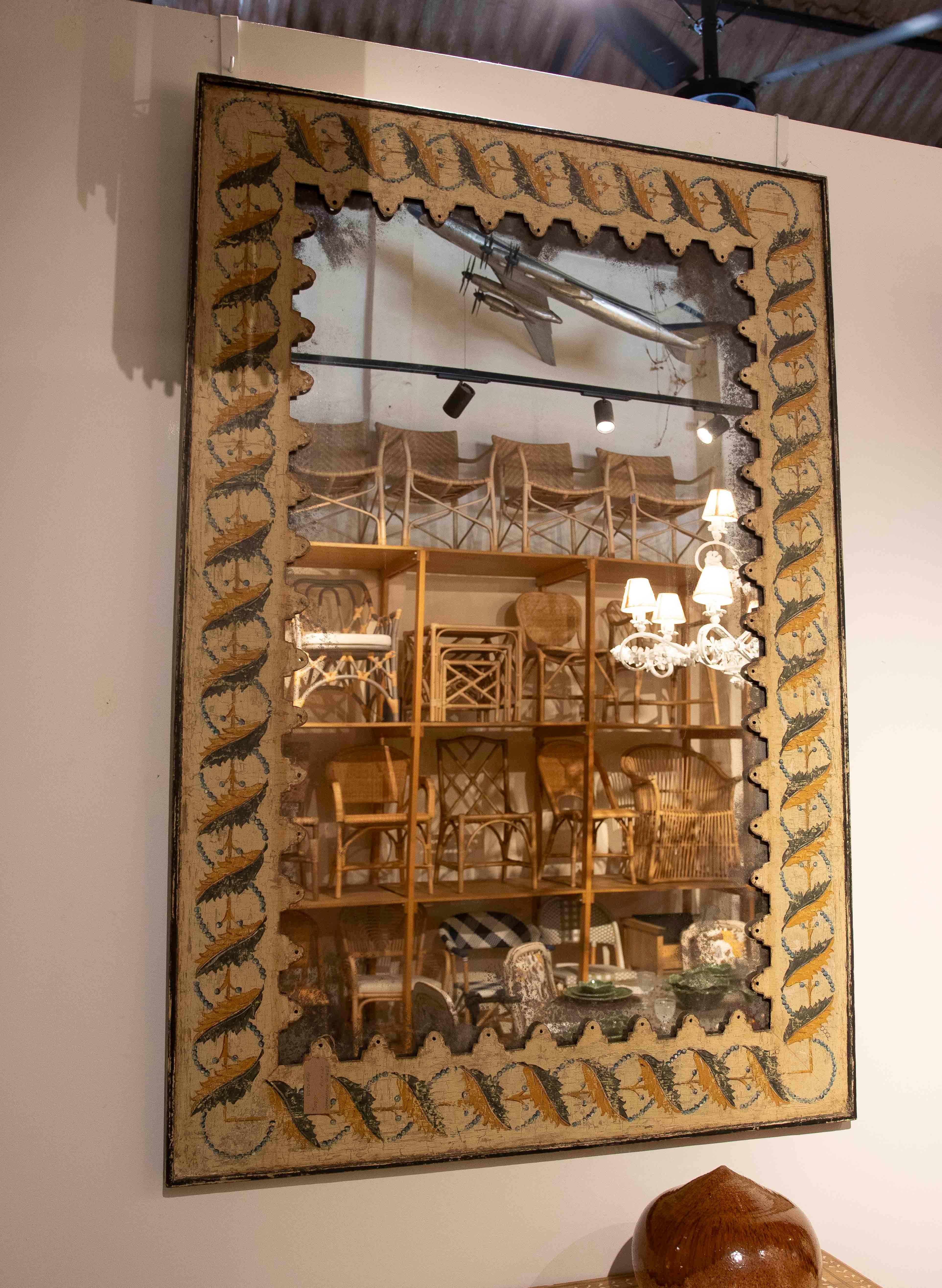 A set of two antique mirrors that stand out for their decorative charm and handcrafted character. Each piece features a hand-painted wooden frame with a geometric design in ochre and green tones, giving it a rustic and authentic feel. The mirror