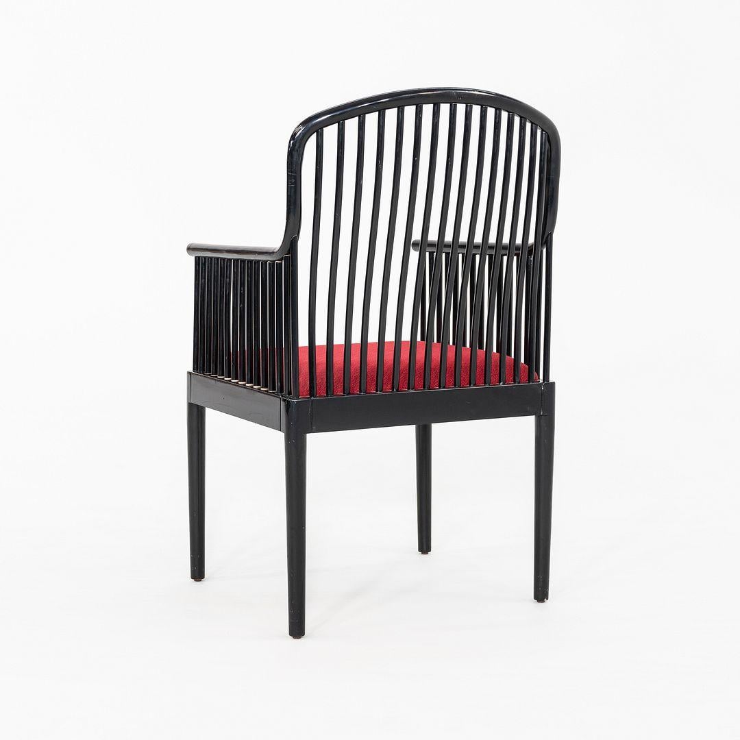 This is a pair of Exeter Dining Arm Chairs, originally designed by Davis Allen for Knoll in 1993. These particular examples date to the 1990s. They are comprised of a wood frame, with a cushioned seat upholstered in a red fabric. The listed price