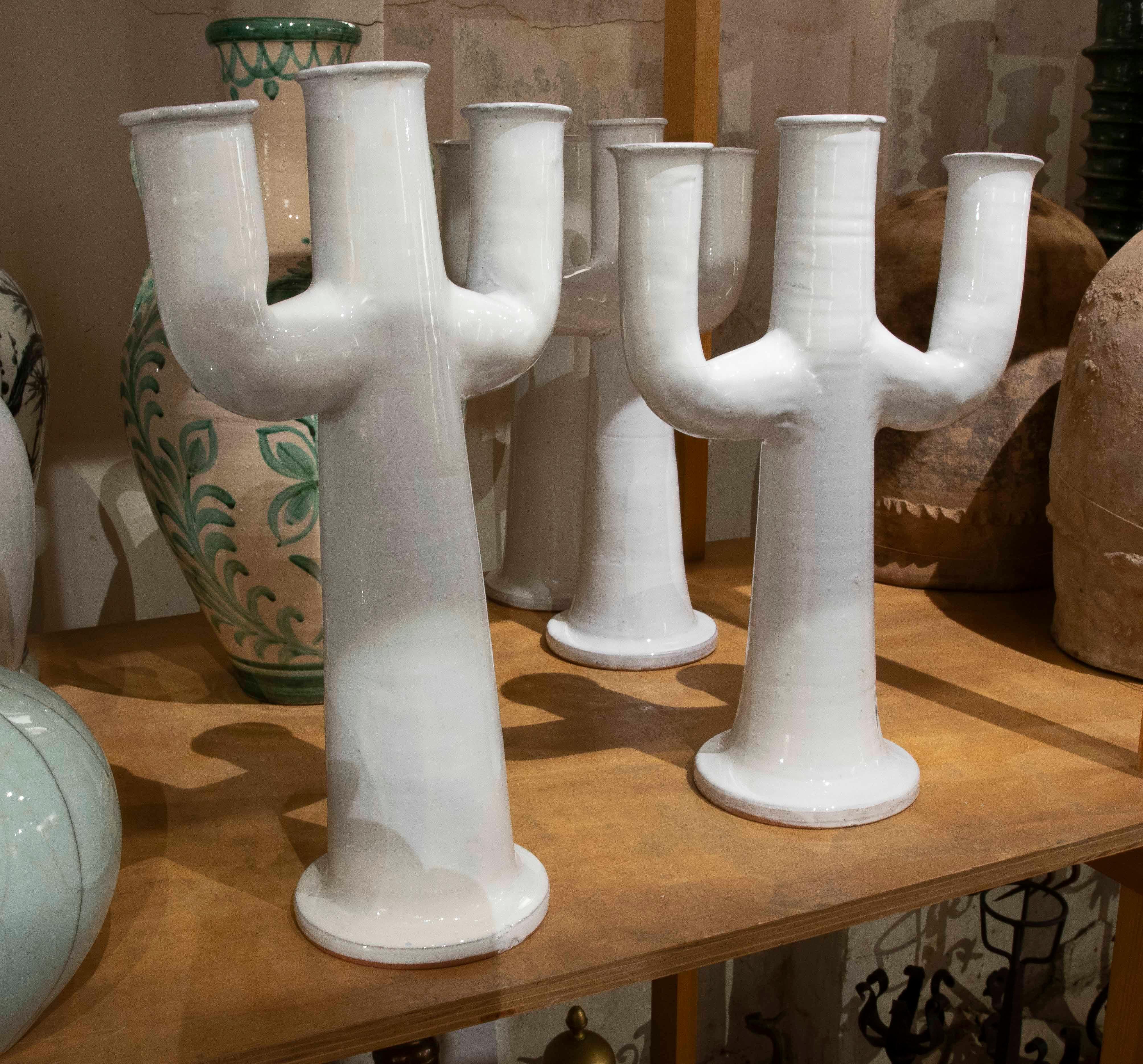 An elegant pair of candlesticks crafted from white glazed ceramic, designed with a unique silhouette inspired by a multi-armed cactus. Their clean, glossy finish lends a contemporary touch, while their sculptural design makes them decorative pieces