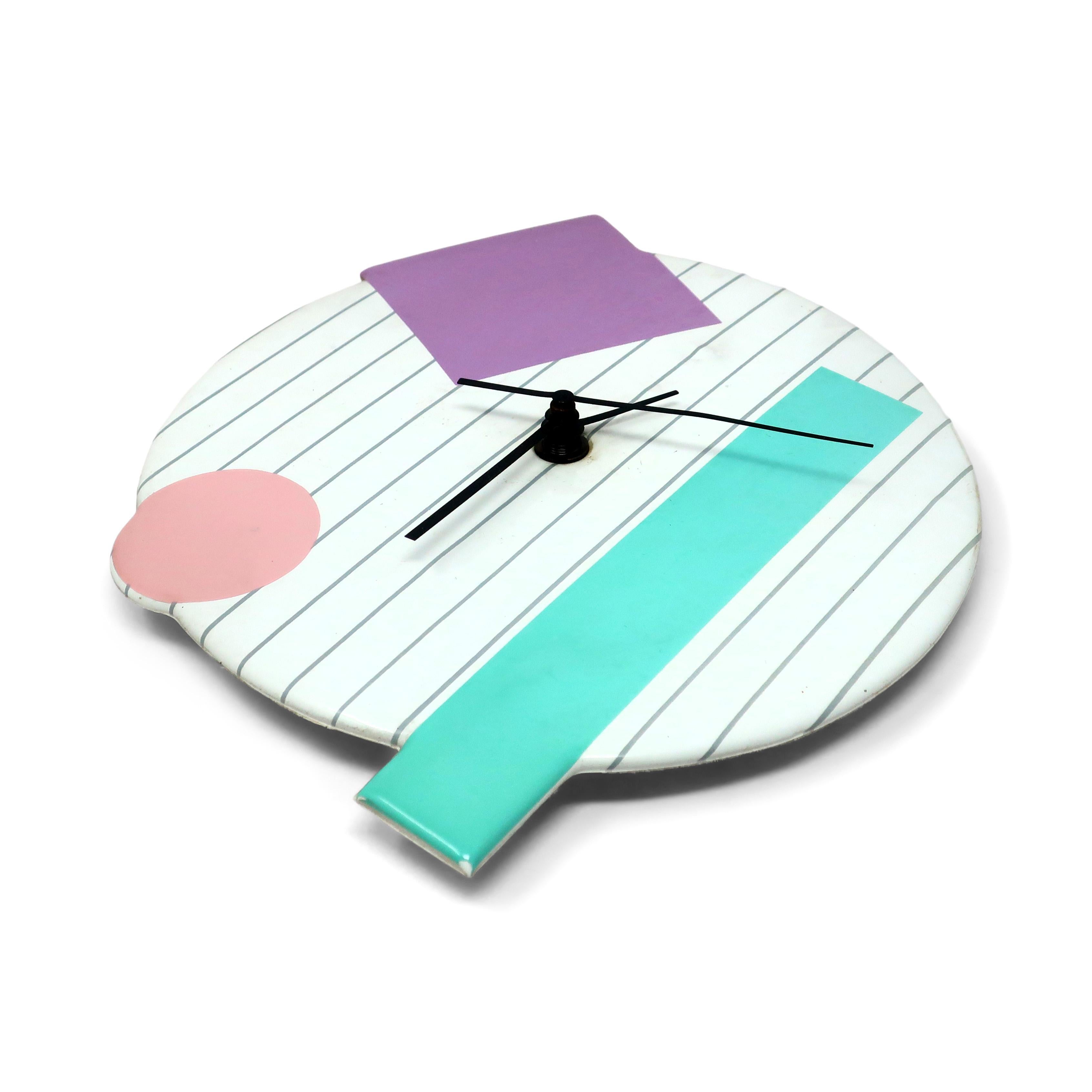 A fantastic postmodern, Memphis-inspired geometric wall clock with black hands, gray strips, and pastel primary colored accents by Small World Greetings from the 1990s.

In good vintage condition with wear consistent with age and use, including