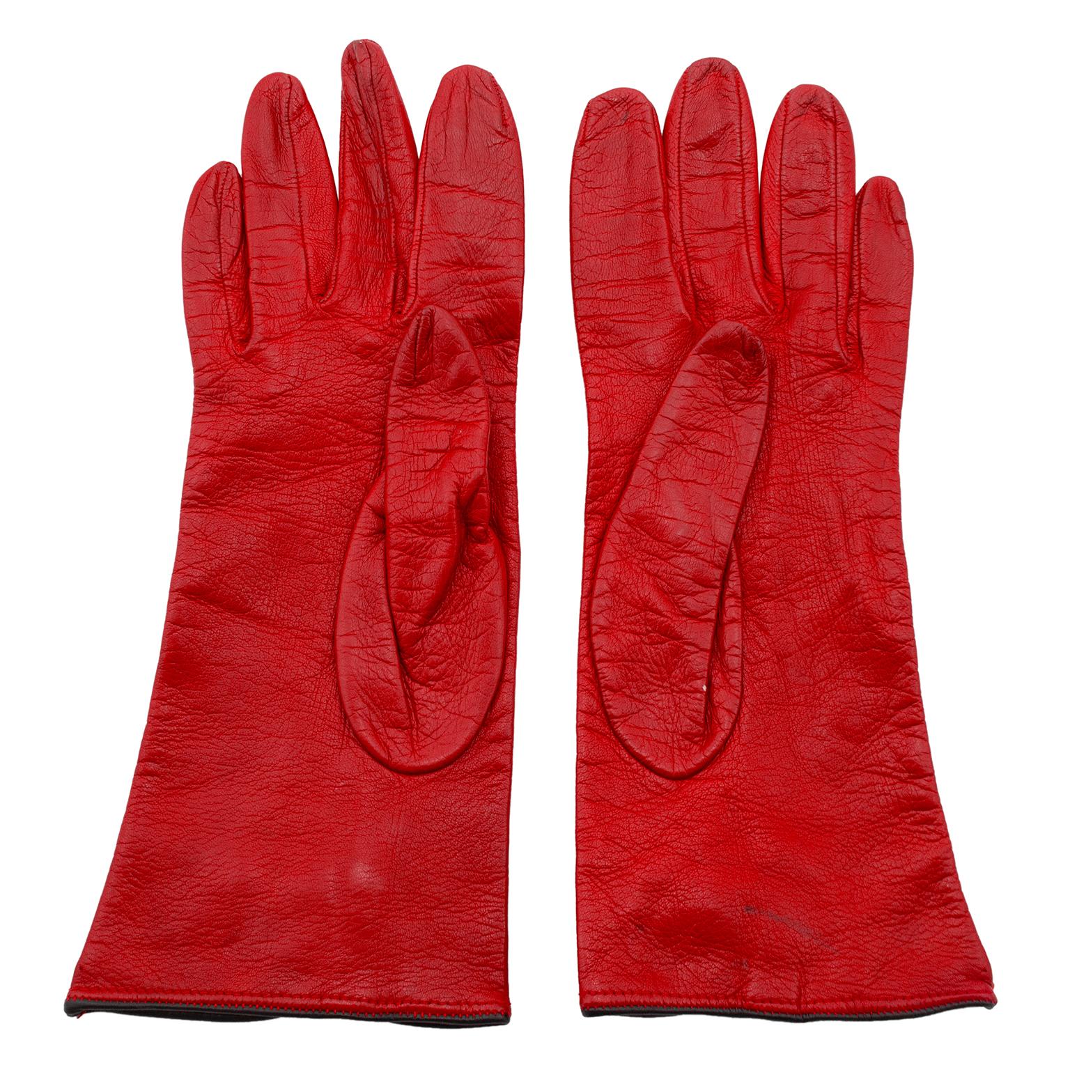 1990s Perry Ellis red leather gloves. Black cord details at wrist with a keyhole and knot button. Black leather trim. Very good vintage condition - slight wear throughout. Marked size 7. Made in Italy. 9.5