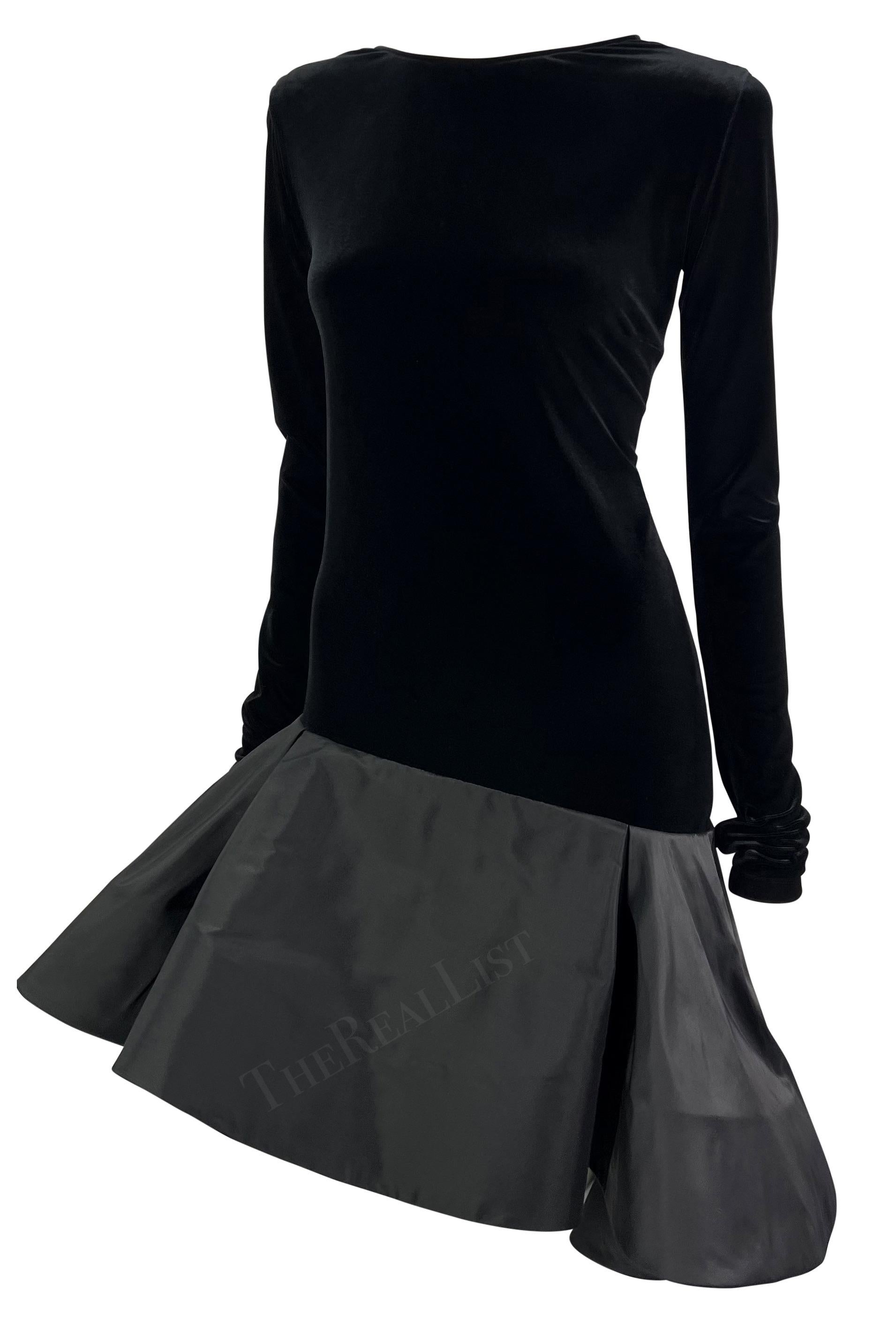Presenting a fabulous black velvet Pierre Cardin haute couture flared dress. From the early 1990s, this fabulous long-sleeve dress features a black velvet top and is made complete with a voluminous flared skirt that asymmetrically connects to the