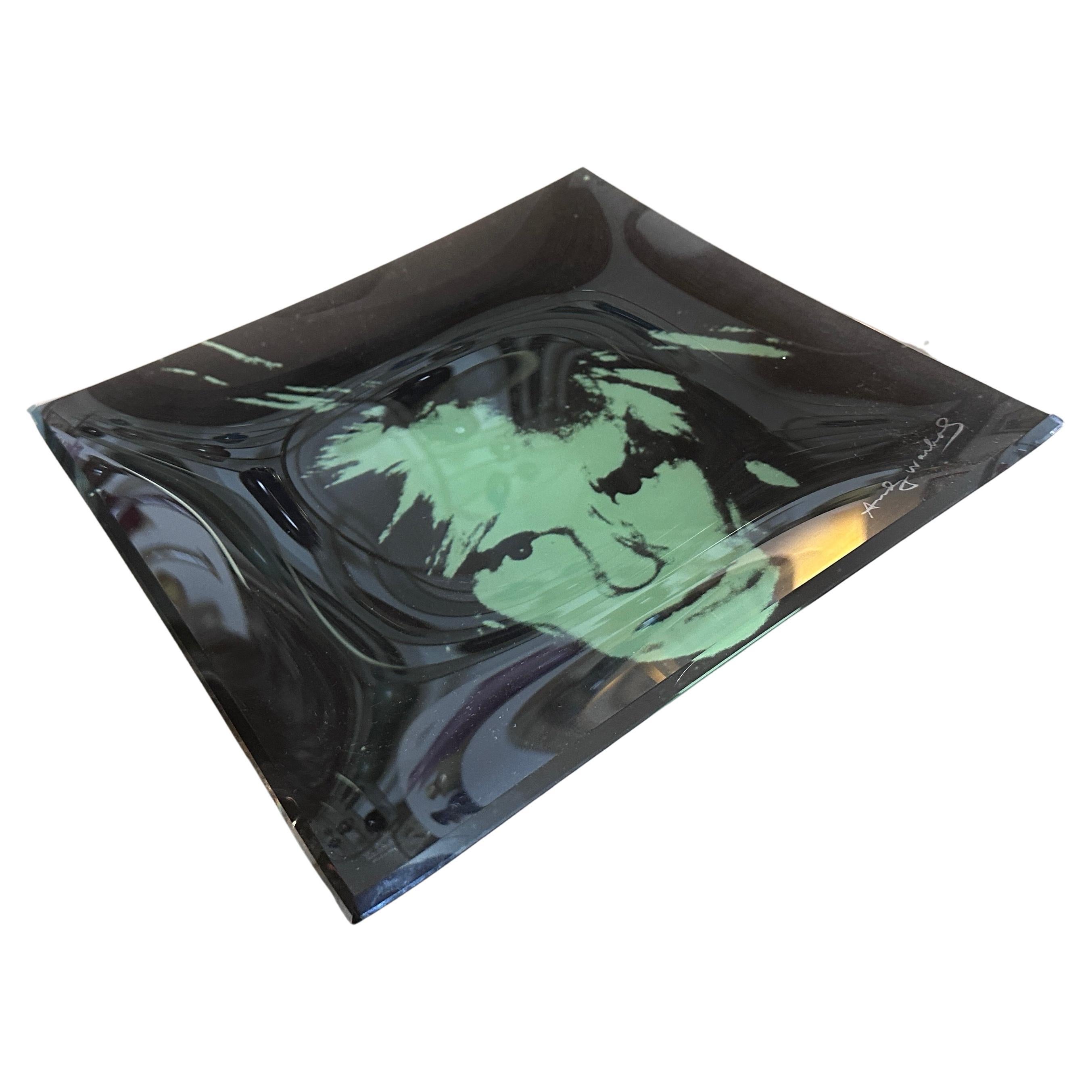 This Self portrait Curved Glass Tray, designed by the iconic artist Andy Warhol, epitomizes the spirit of the era's vibrant and bold artistic movement. Blending Warhol's distinctive style with functional design, this glass tray serves as both a