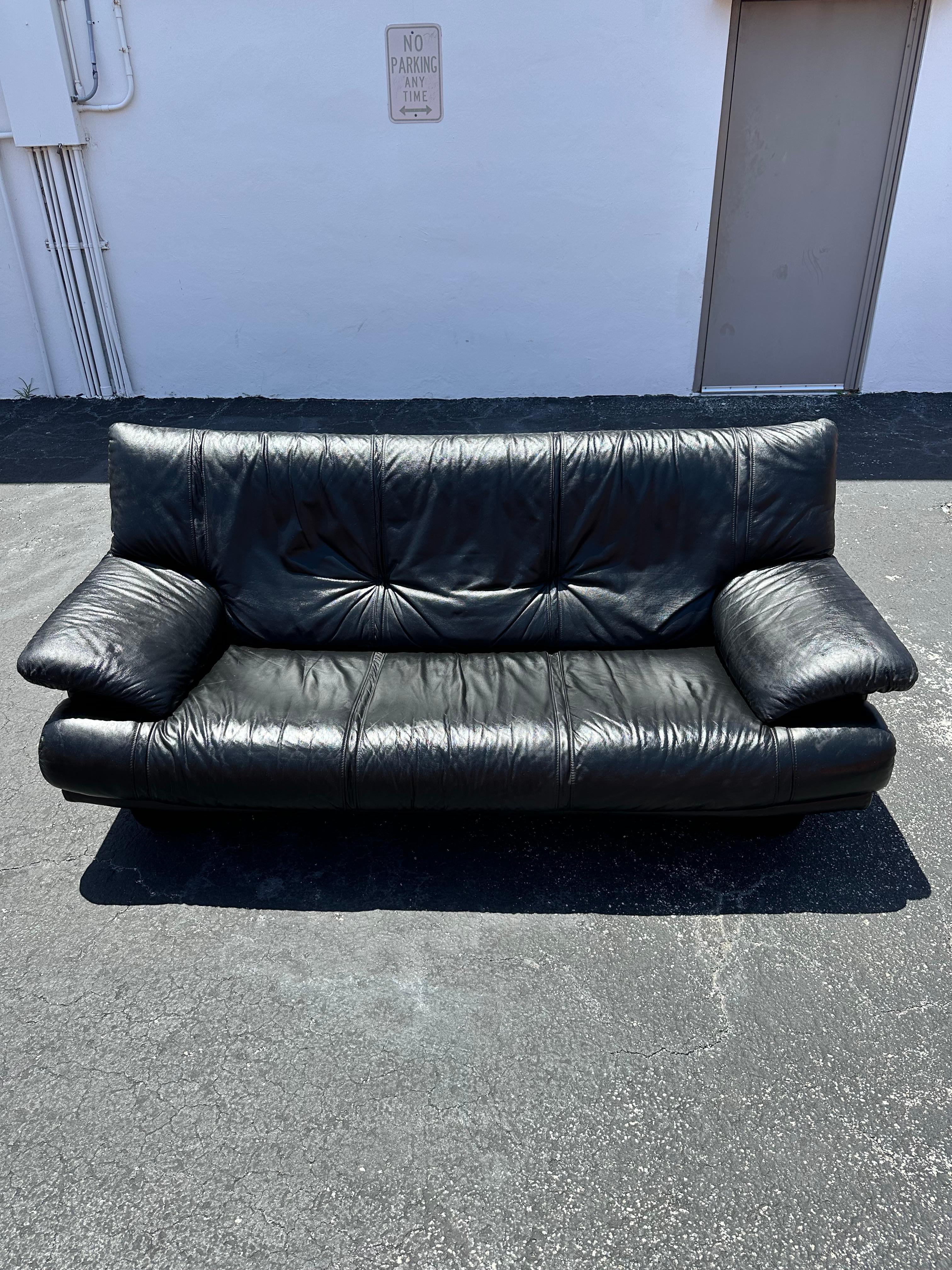 Transport yourself back to the sleek and sophisticated 1990s with this exquisite black leather sofa. The ultra rare sofa exudes an air of luxury and refinement. Outstanding design is exhibited throughout. The luxurious sofa is statement piece which