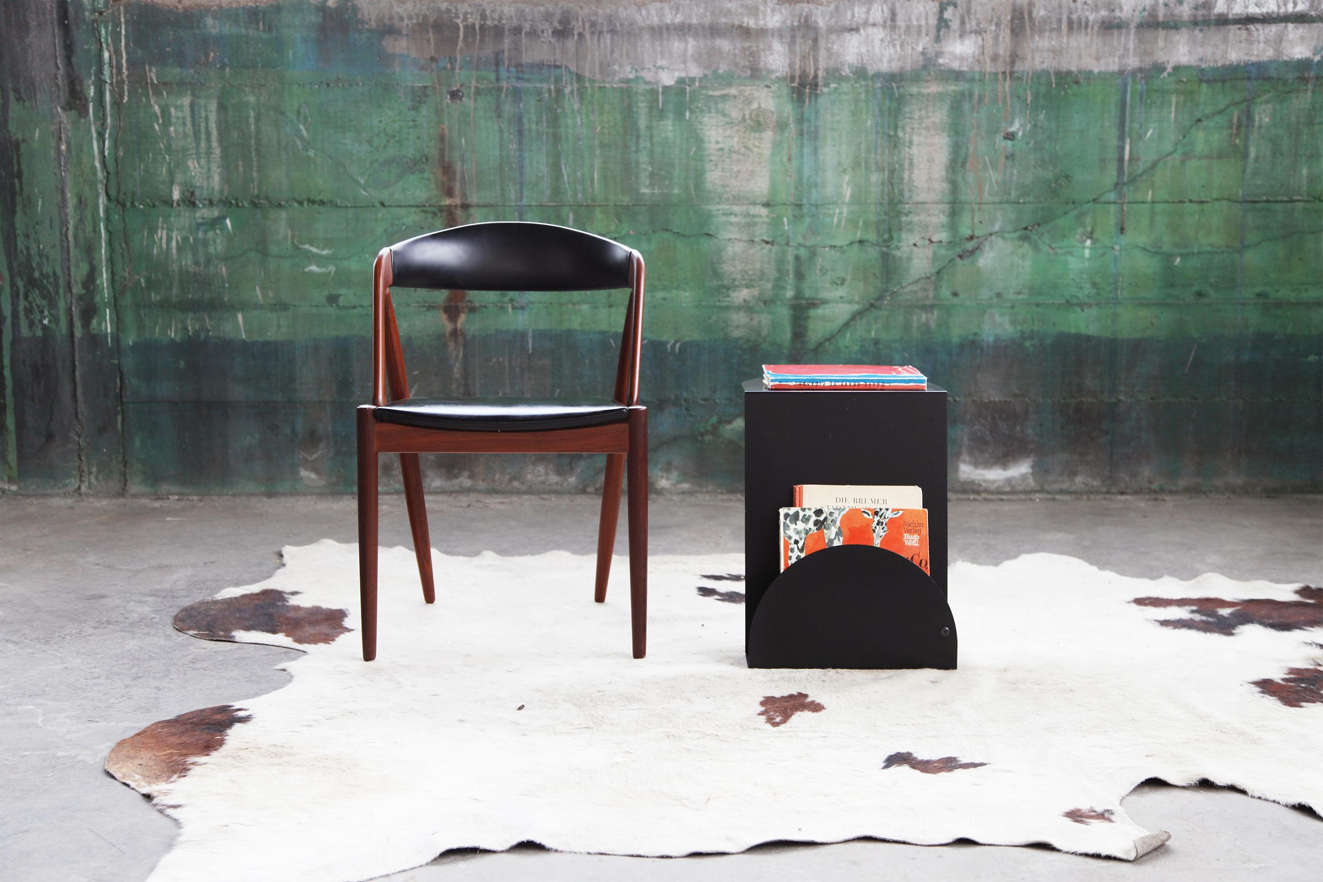 Une excellente pièce d'accentuation. Cette table d'appoint porte-revues en métal noir s'intègre parfaitement dans un décor Modern-Decor ou Mid-Century. Il présente un superbe design sculptural et ne prend pas beaucoup de place, mais il offre une