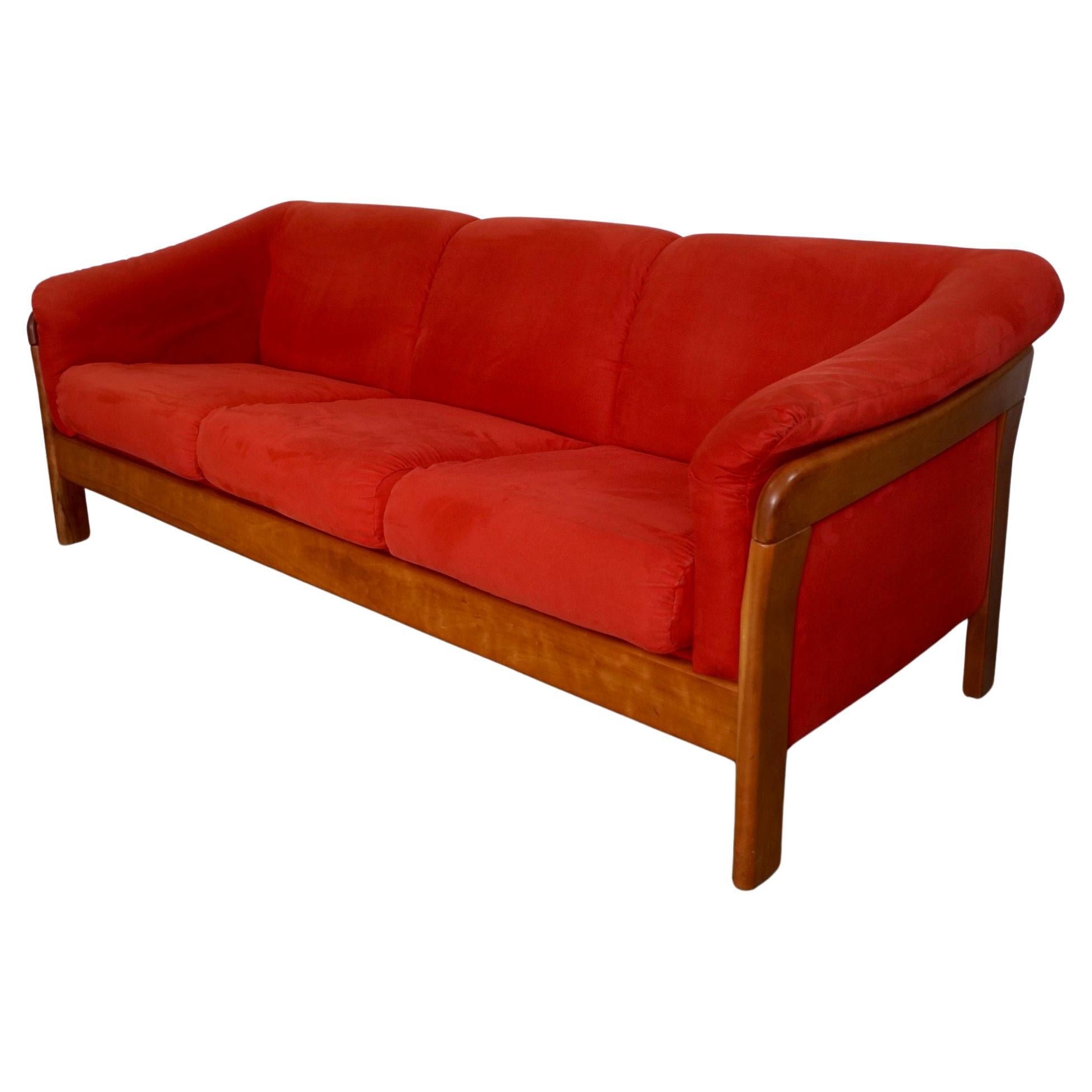 Vintage Midcentury Modern sofa for sale. Has a solid teak frame, and was manufactured by KSL Furniture in the 1990's. It has the original faux suede upholstery in red, and is in excellent condition. The fabric has no rips, tears, or stains, and was