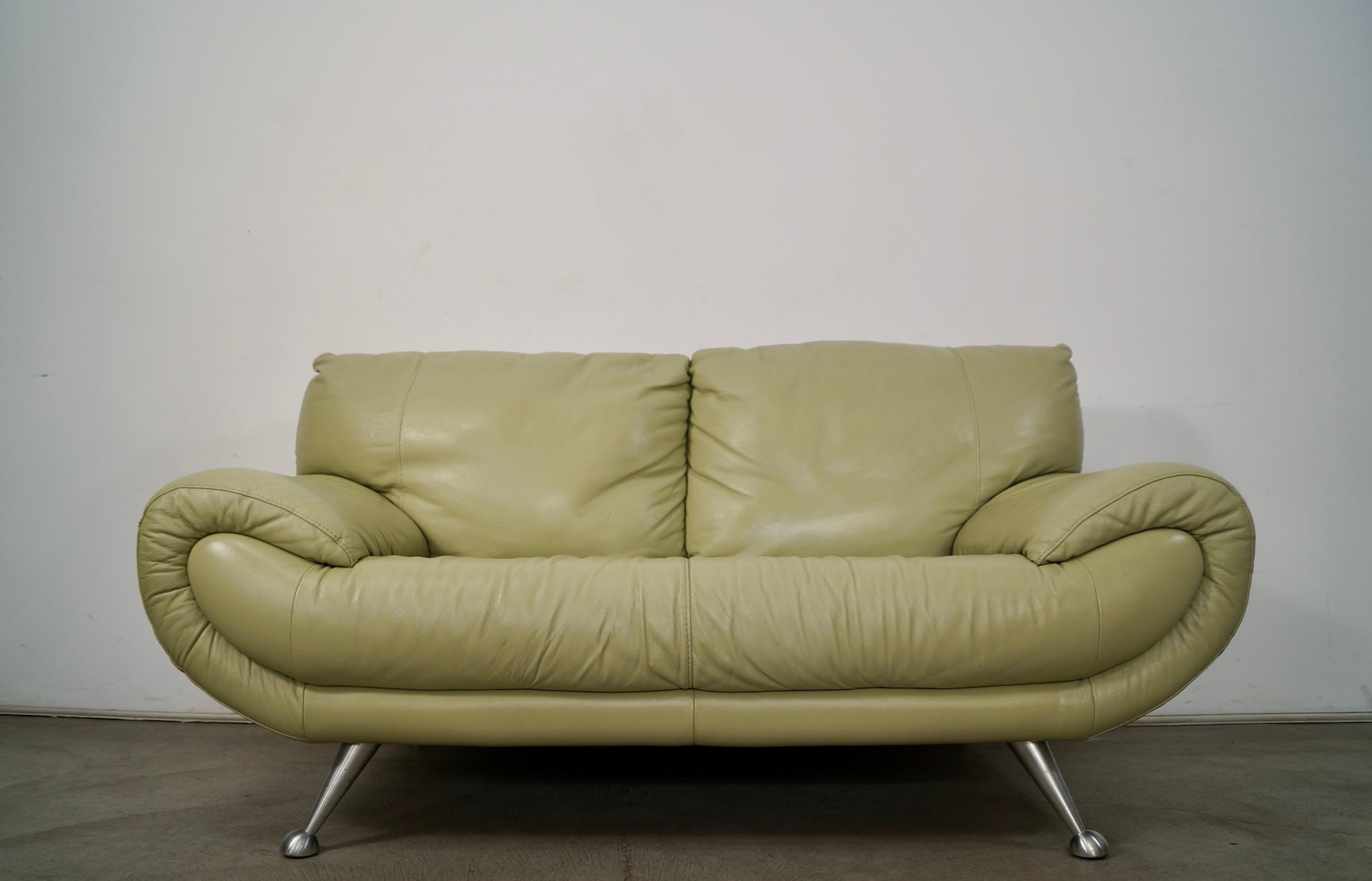 Vintage Post Modern leather couch for sale. It was manufactured by Nicoletti, and was made in Italy. It's leather with a soft green tone, and has four angled cast aluminum legs. It's really solid and well built, and has a gondola design. Classic