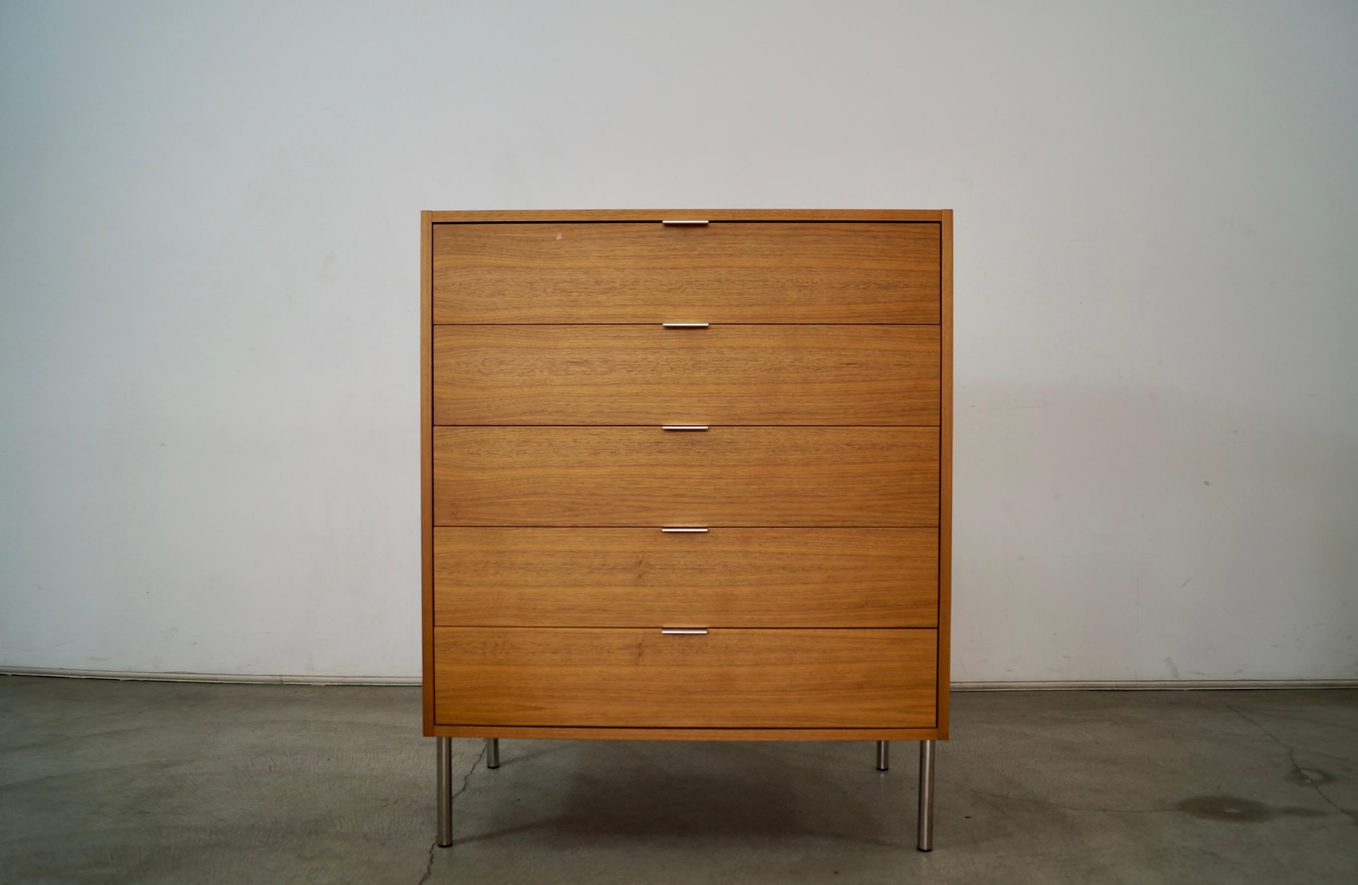 Vintage Post Modern dresser for sale. Designed by Niels Bendtsten for Designed Within Reach in 1996, and part of The Reve Collection. It's made of walnut with tall stainless steel cylinder legs and polished aluminum handles. The drawers all open and