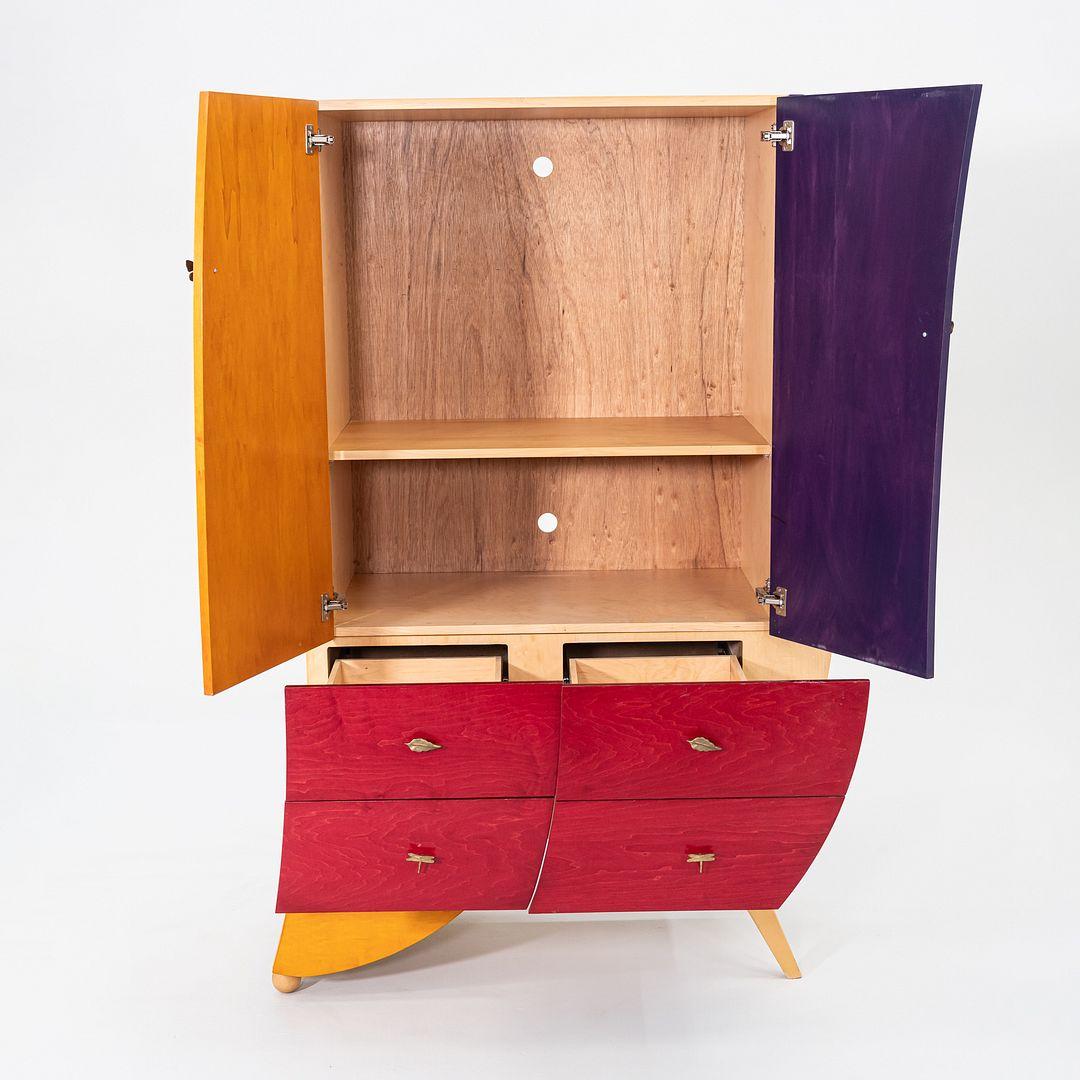This is an unusual Postmodern Studio Craft Sculptural Armoire in Aniline-Dyed Maple, dating to the 1990s. We also have a coordinating left-leaning armoire available for separate purchase. The cabinet was handcrafted from solid woods, and has a