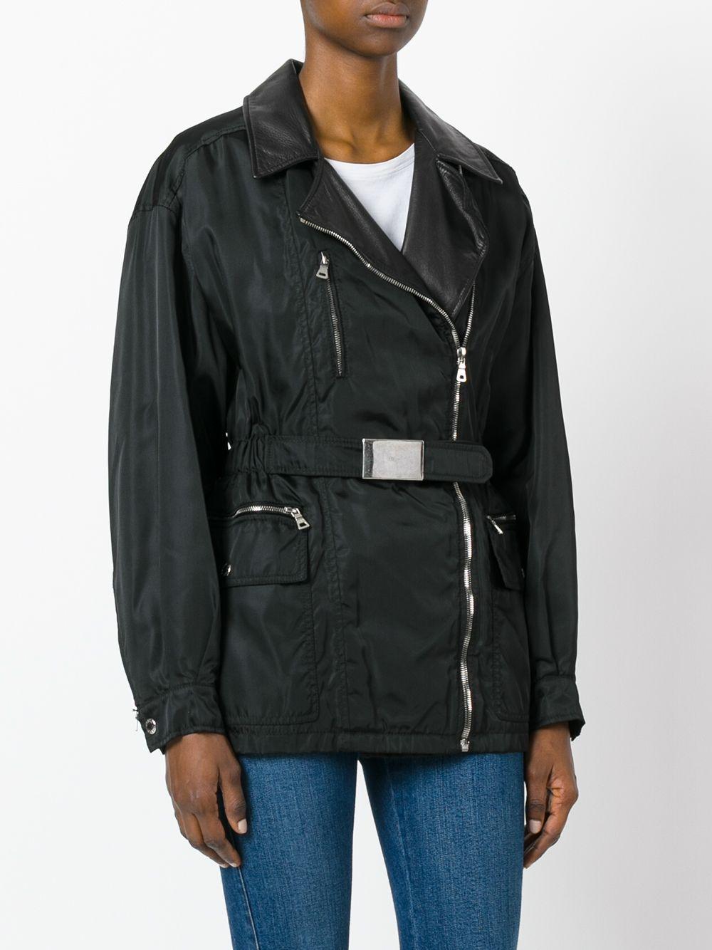 Prada black nylon jacket with leather collar, front zip closure, long sleeves with zip and button on the cuffs, five front pockets, three with zip and two with flap and logoed snap button, belt at the waist.

Years: 90s

Made in Italy

Size: 46