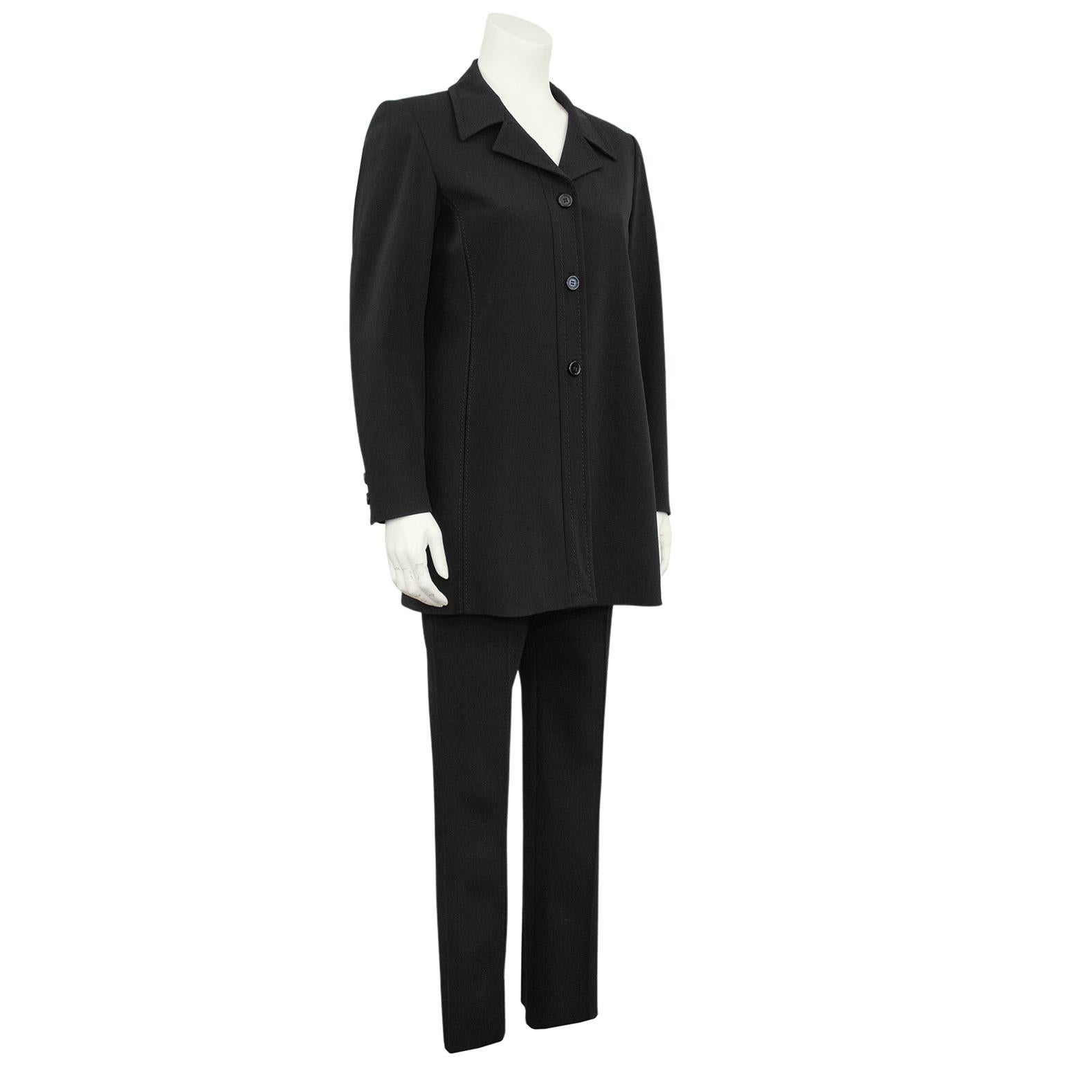 Very chic and minimal 1990s Prada pantsuit. Slightly oversized, long blazer with large notched collar, three buttons centre seam closure and double back vent. Coordinating mid rise pleated straight leg trousers with invisible side zipper. Tonal top