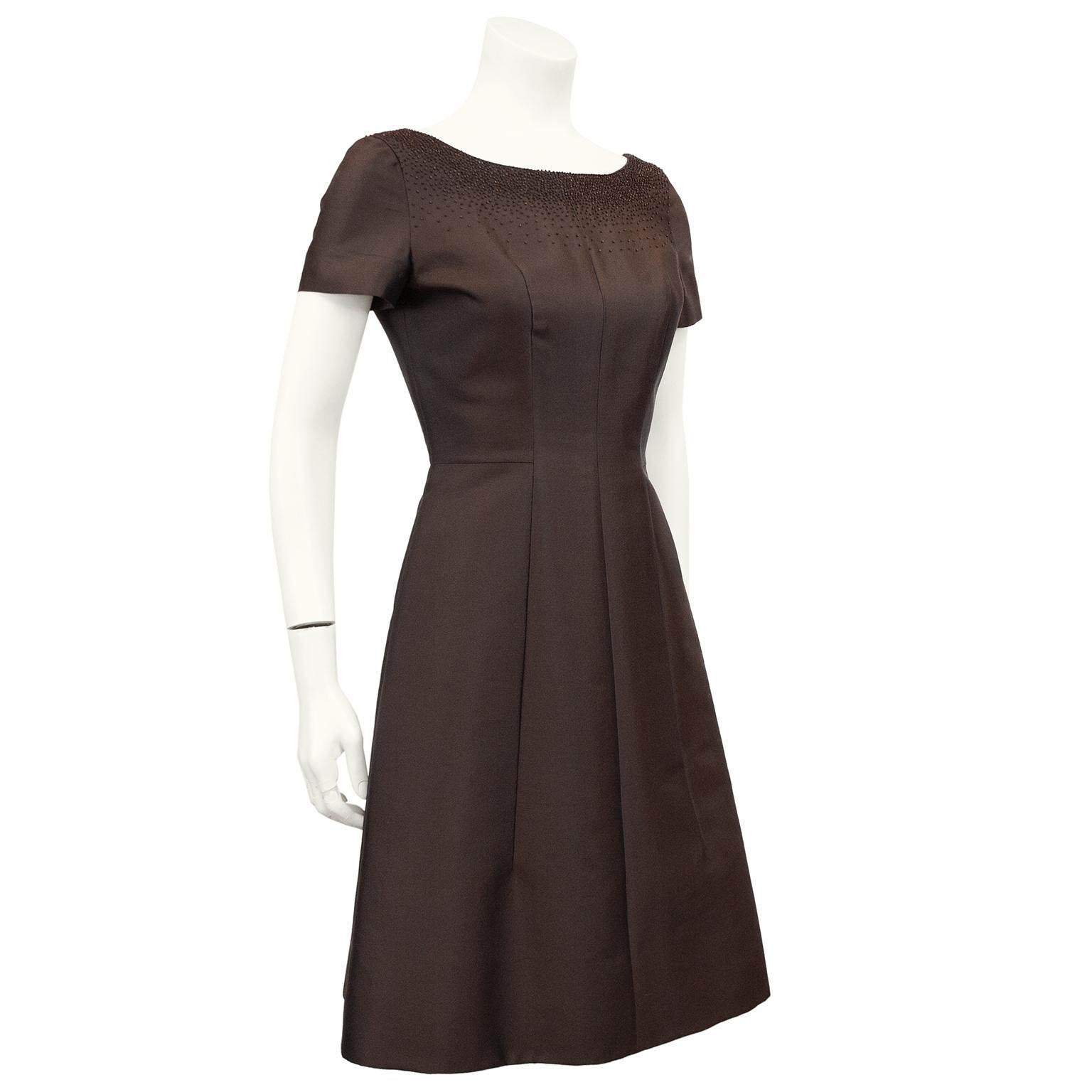 Stunning Prada cocktail dress from the early 1990s. This dress clearly is inspired by the clean and beautiful silhouettes from the 1950's. Chocolate brown silk taffeta with cascading tiny monochromatic beading that embellishes the neckline. Short