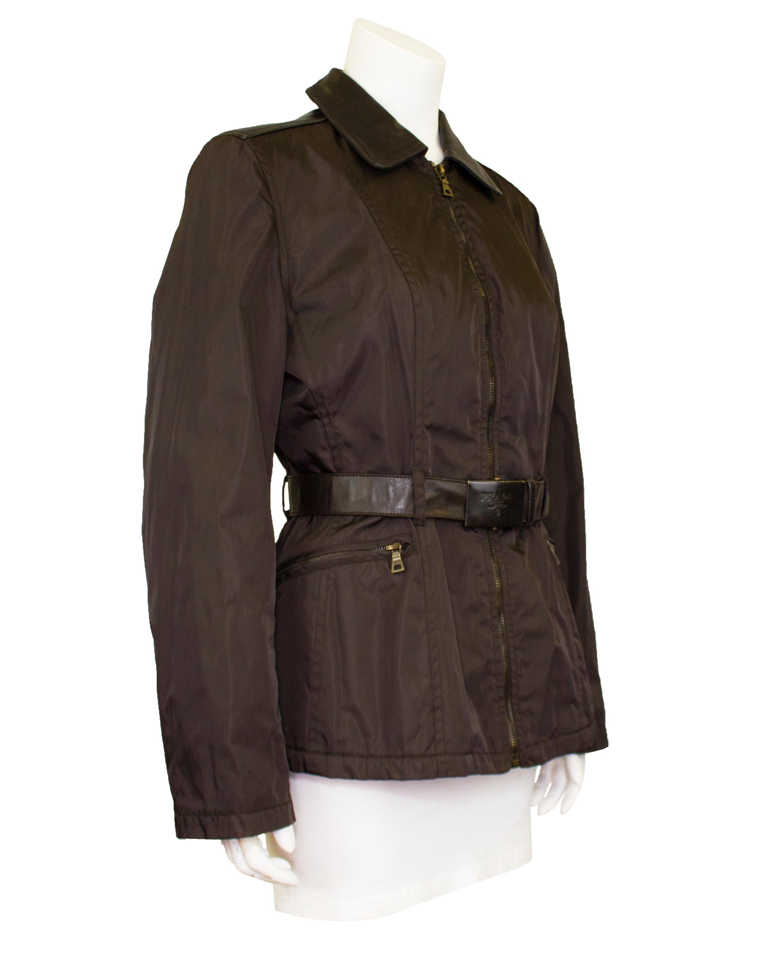 This is a great Prada jacket from the early 1990s. The arms and body of this piece are constructed from the iconic Prada nylon, while the collar, shoulders and belt are supple brown leather. The perfect mix between utility and fashion, this jacket