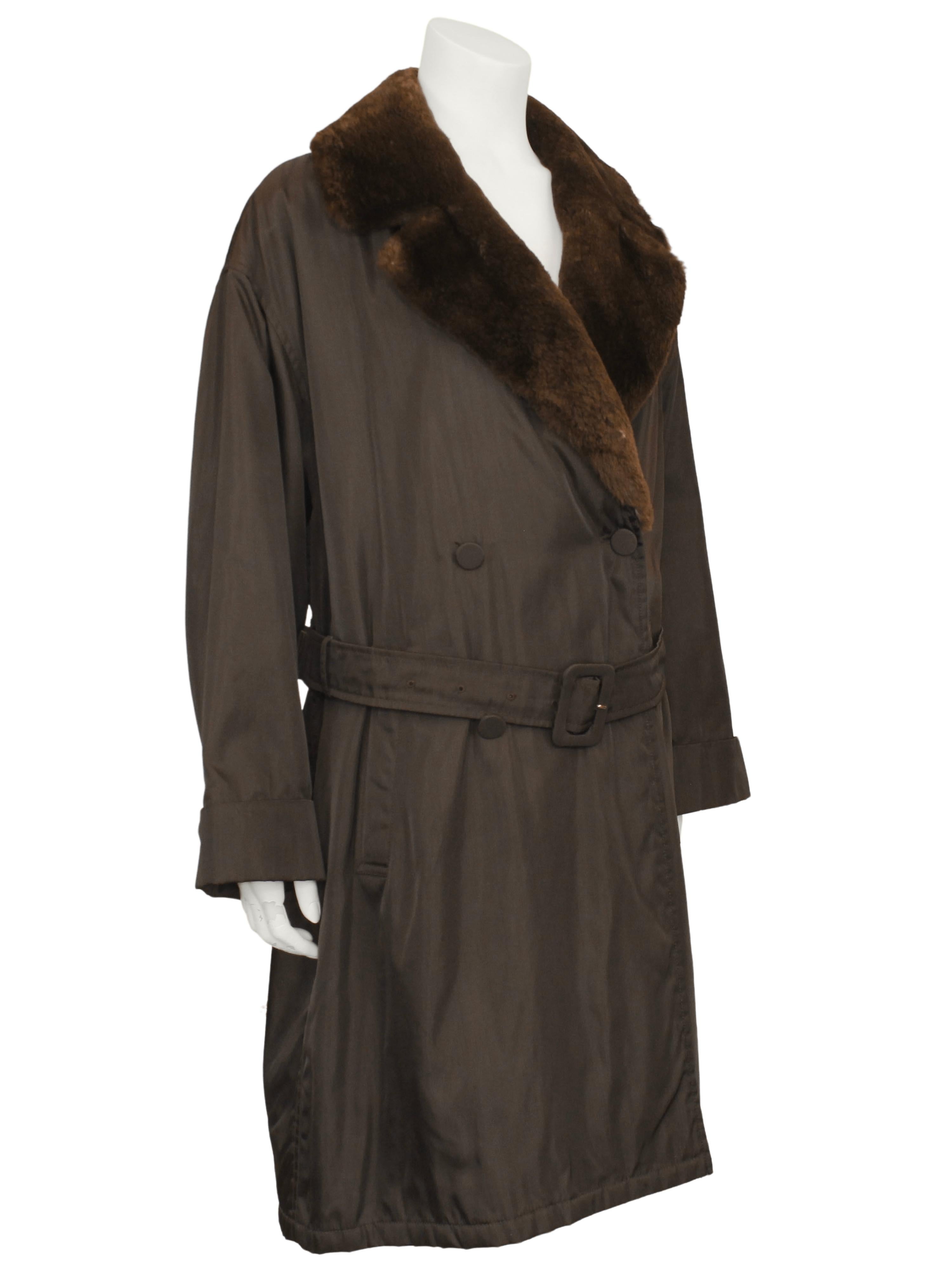 Early collection Prada chocolate brown techno-nylon double breasted belted trench coat from the 1990s. The coat features an oversized notched brown faux fur collar and brown fabric covered buttons. Lightweight with quilted interior for warmth. A