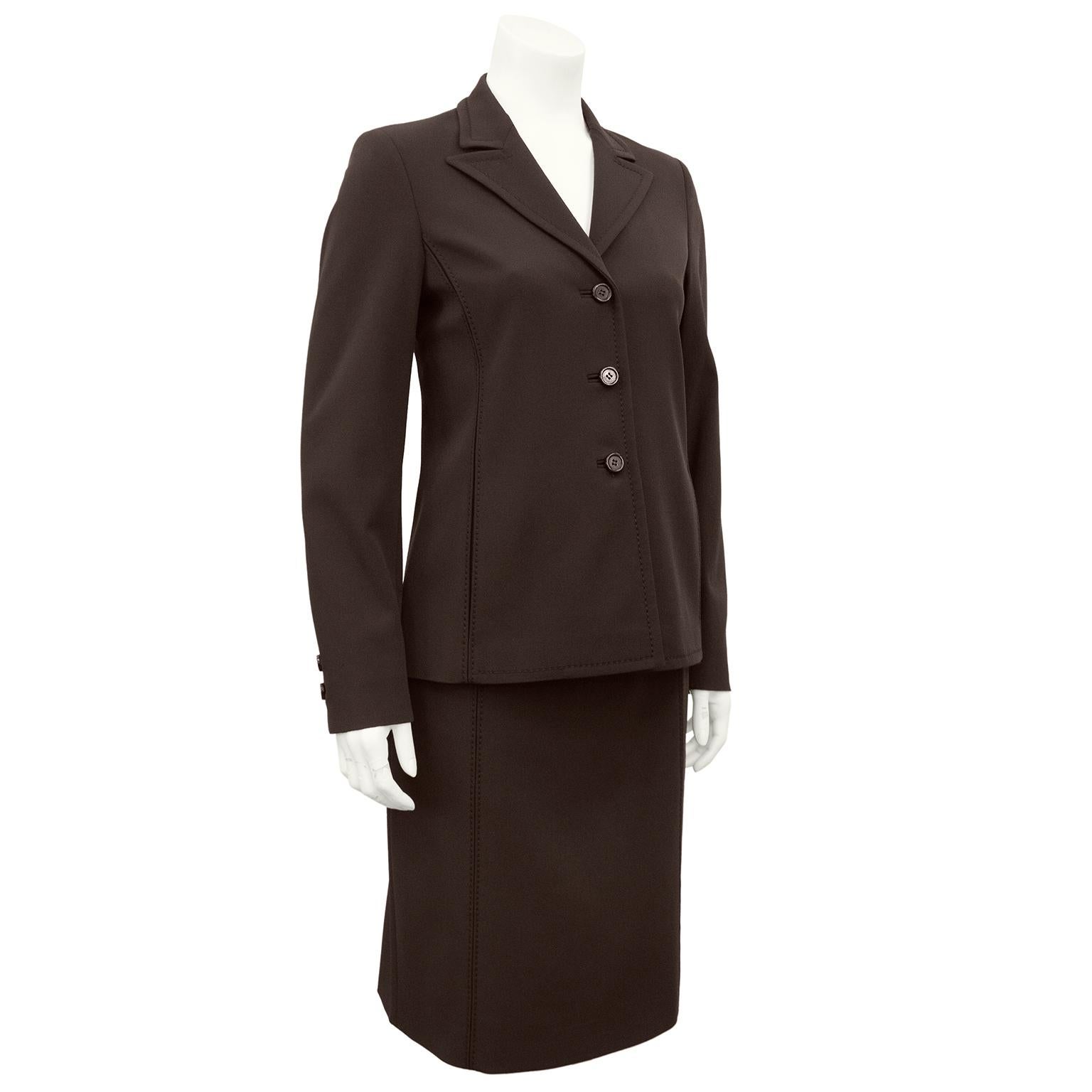 1990s brown Prada skirt suit made from Prada's iconic technical stretch nylon. The fabric wears incredibly well and does not wrinkle. Jacket is a classic blazer with a notched collar and three monochromatic brown plastic buttons and top stitching.