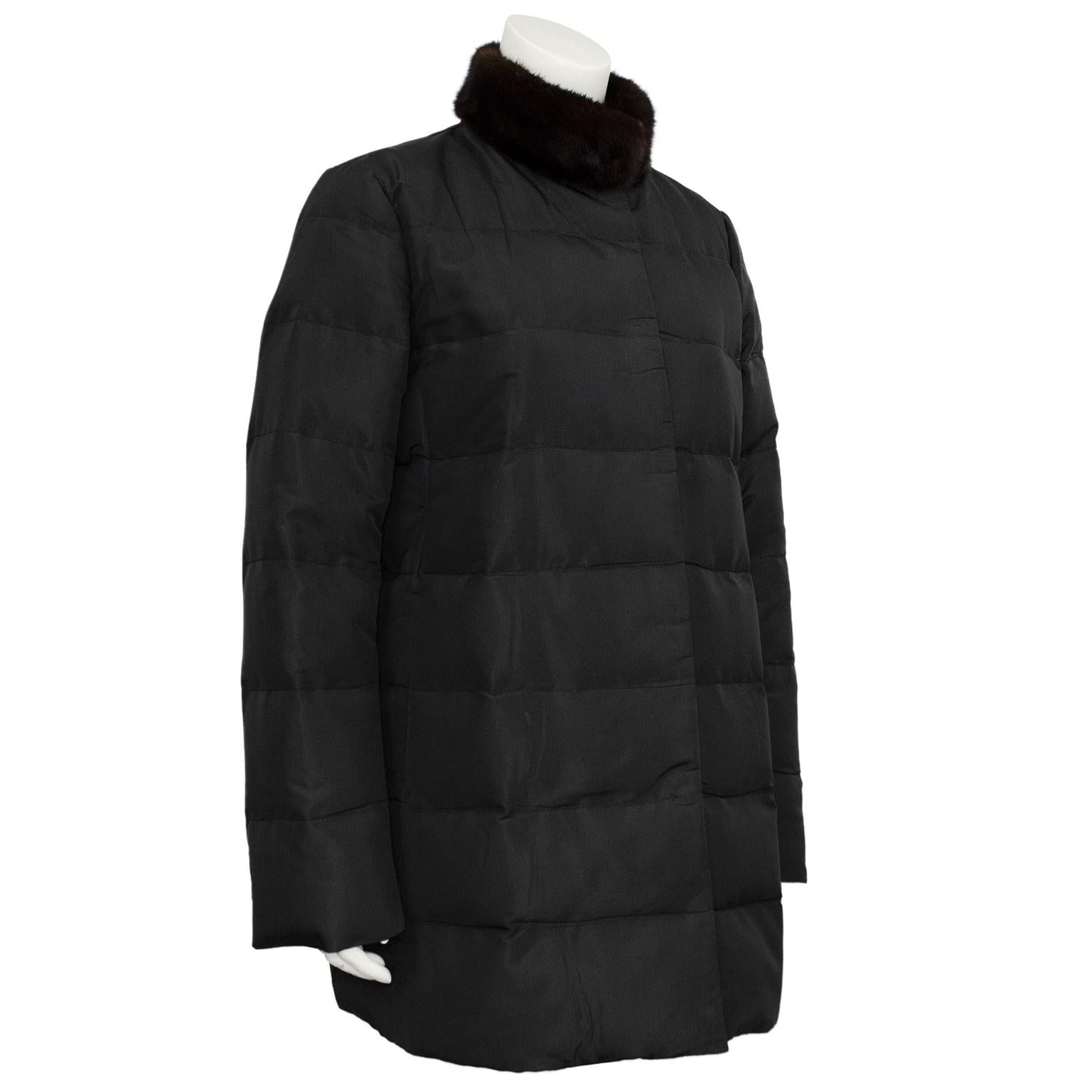 Understated and chic Prada down puffer coat from the 1990s. Black nylon with brown mink collar. Hidden snap buttons down centre front seam. Black grosgrain ribbon trim down both interior centre seams. Vertical slit pockets. Tonal black stitching.