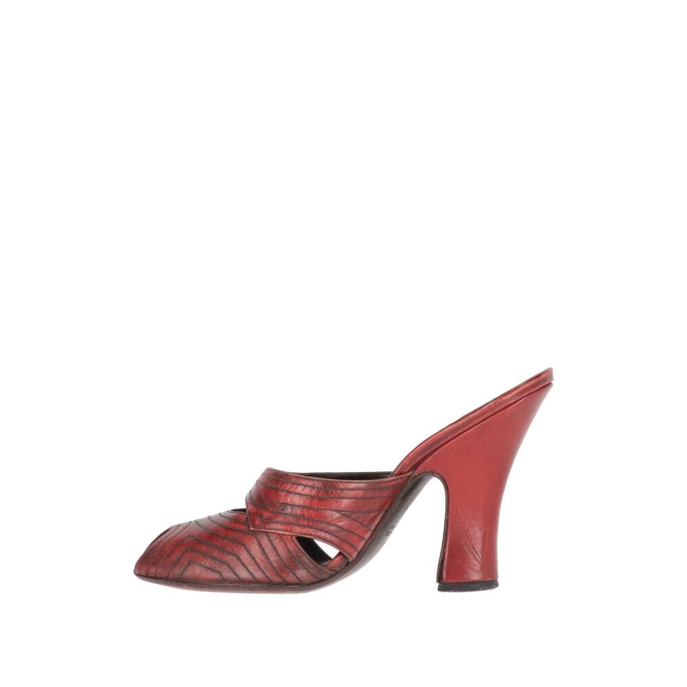 Prada dark red leather mules. Open toe model, decorative cut-out details and heel. 

The product shows some signs of use on the skin as shown in the pictures. 

Years: 90s 

Made in Italy 

Size: 37 EU  

Heel high: 10 cm 
Insole: 23 cm