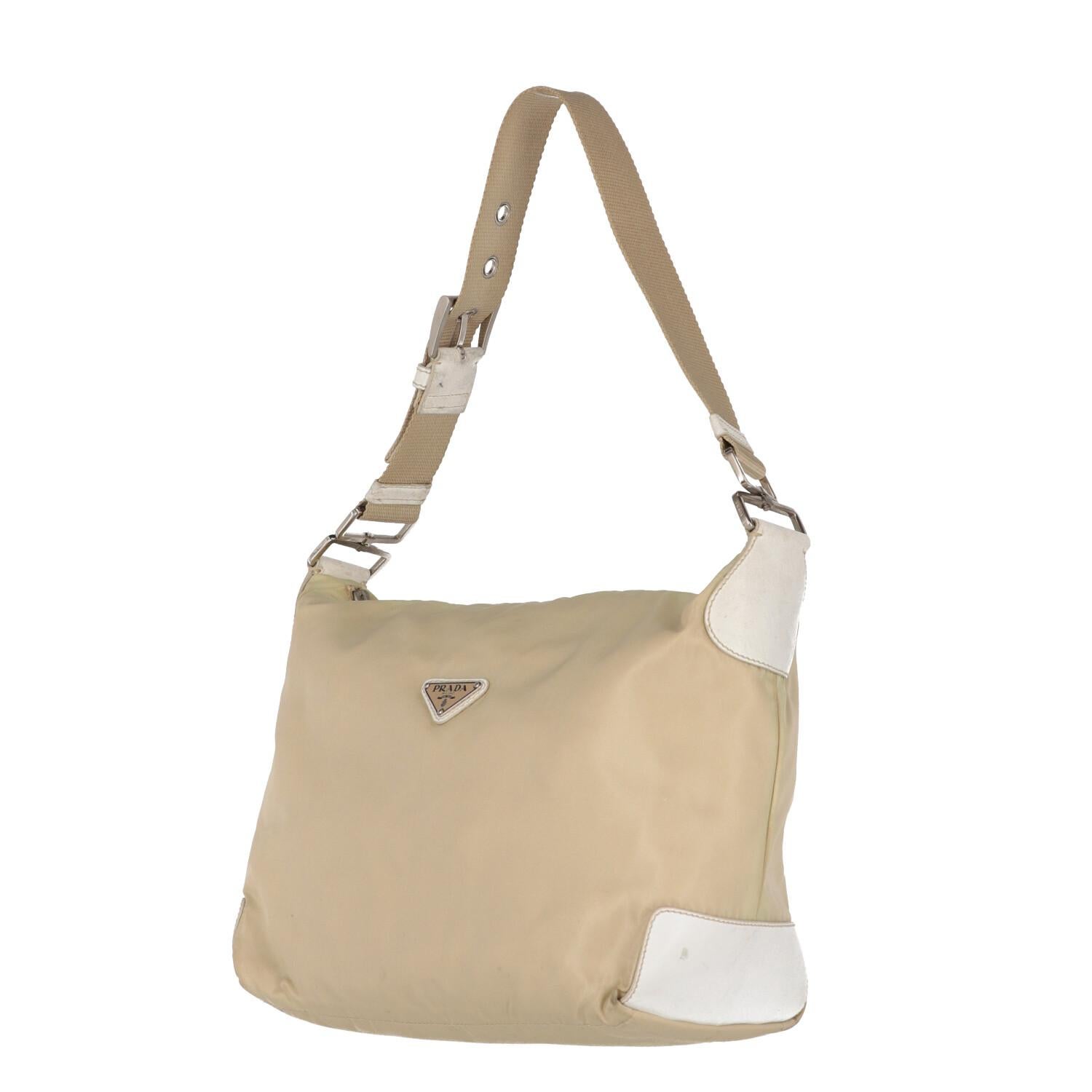 A.N.G.E.L.O. Vintage - ITALY
Prada ivory nylon bag with white eco-leather edges finishing. Cotton ribbon single handle adjustable by silver metal buckle and zip closure.

The product has slight signs of wear on the eco-leather and nylon parts, as