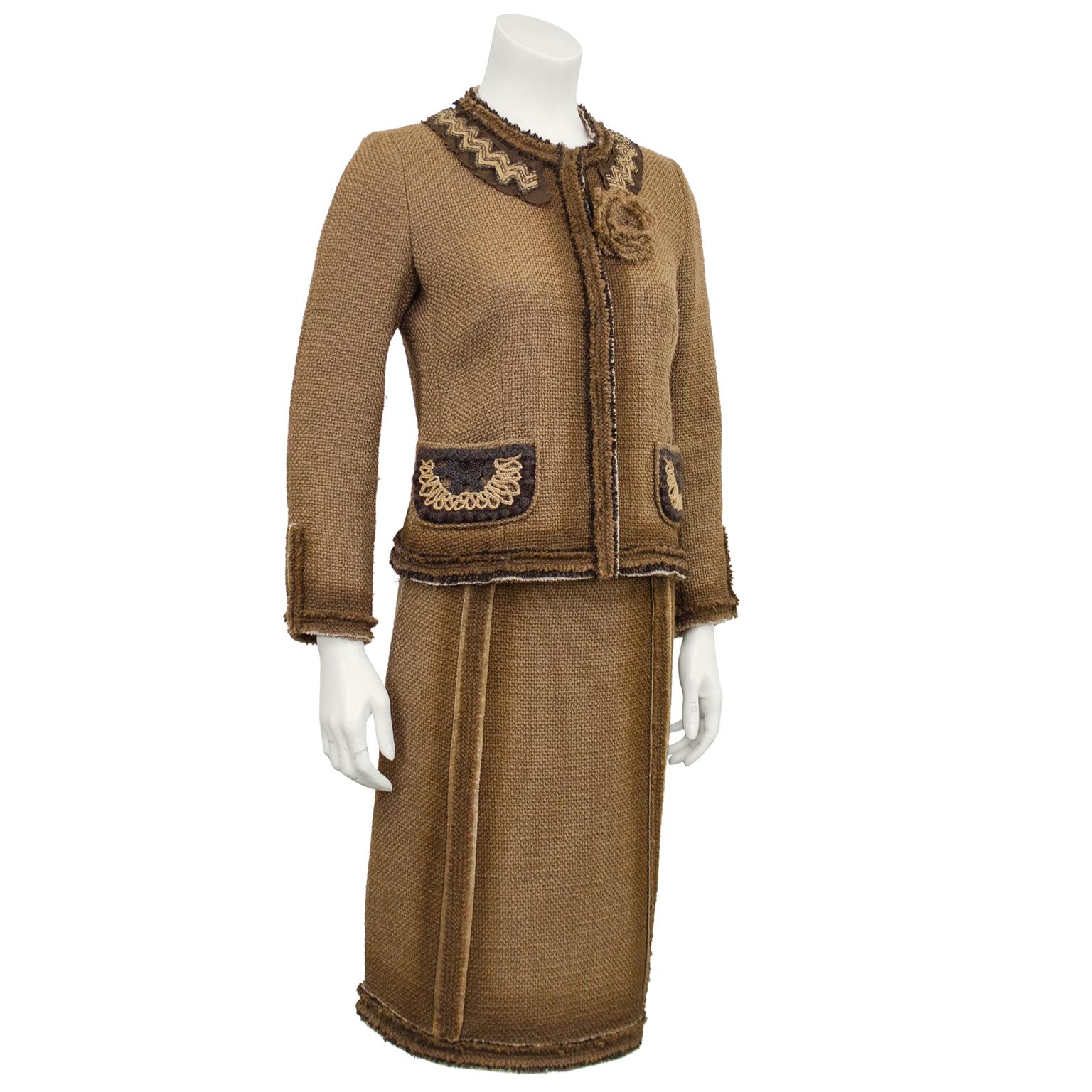 Prada tan woven linen boucle skirt suit from the 1990s. Jacket features crew neck collar with light tan and brown macrame and beaded chevron details and a canvas flower pin. Small brown and tan crochet patch pockets. High waisted very slight a-line