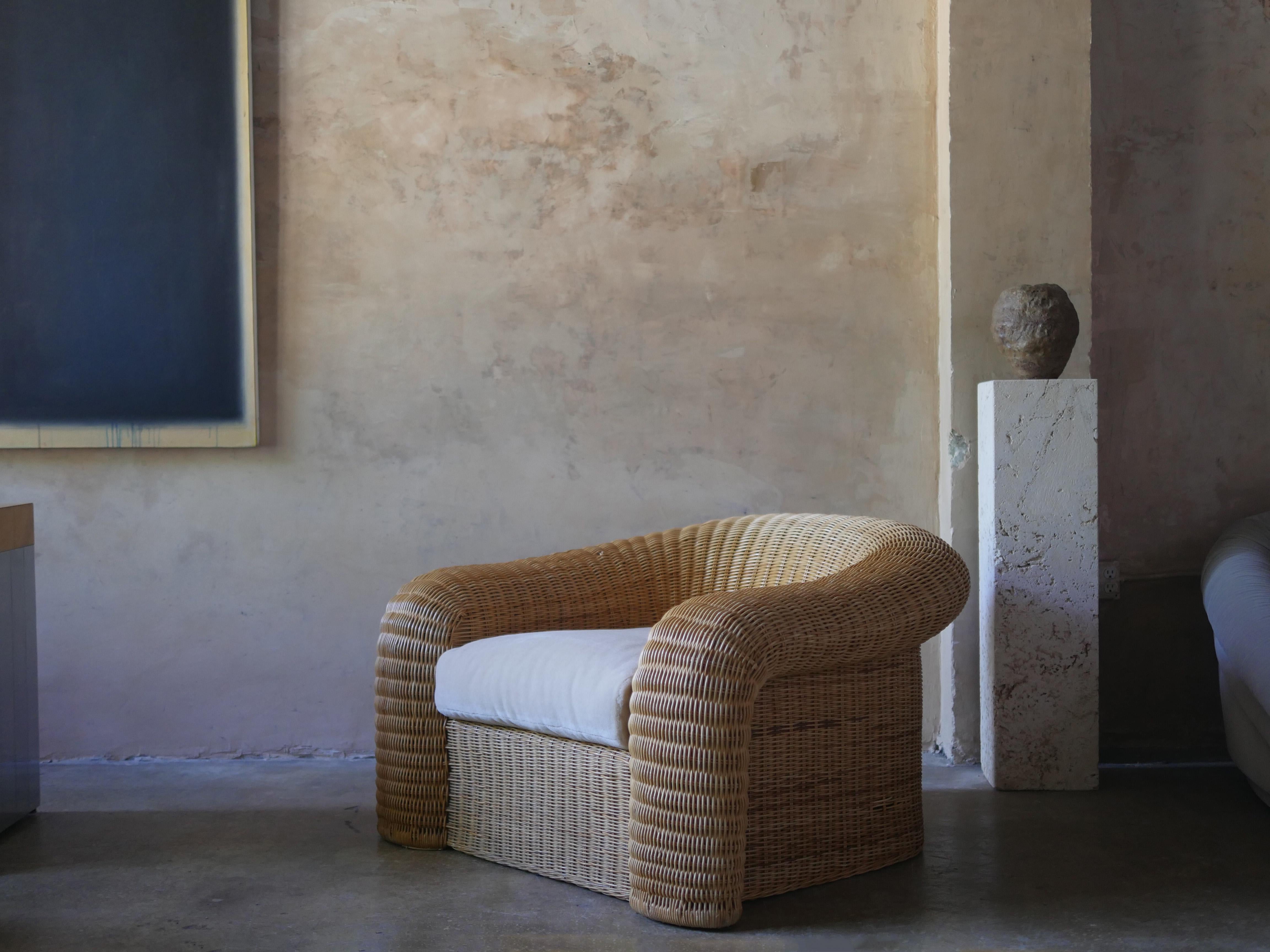 Sculptural 1980s oversized pencil reed rattan lounge chair, with a plush Pierre Frey custom mohair cushion. The chair combines comfort with stunning visual appeal, adding a warm, artisan touch to any room.