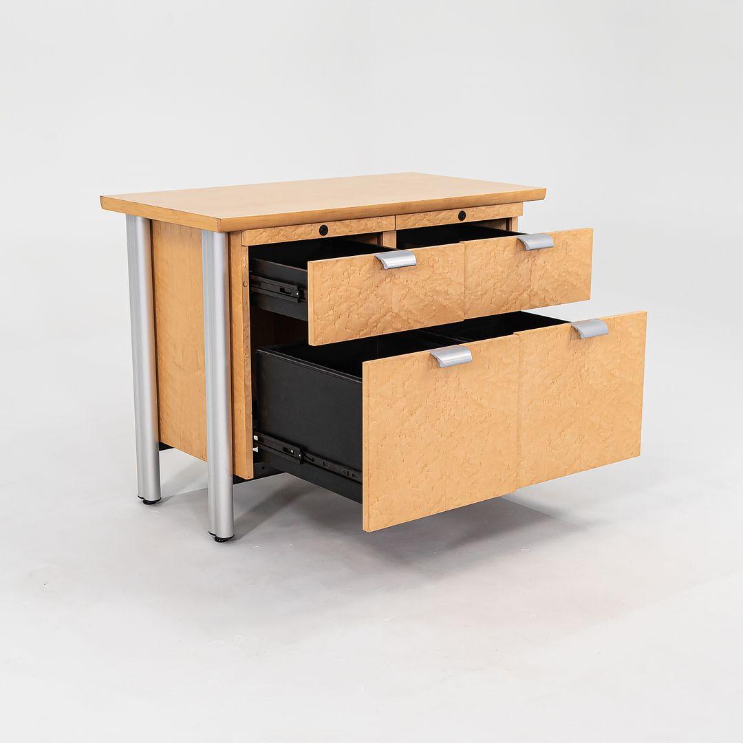 This is a pair of Propeller Credenzas in Birdseye Maple, designed by Emanuela Frattini for Knoll in 1994. The listed price includes one credenza, and we have two available for purchase. Their design features a steel frame, aluminum details, and a