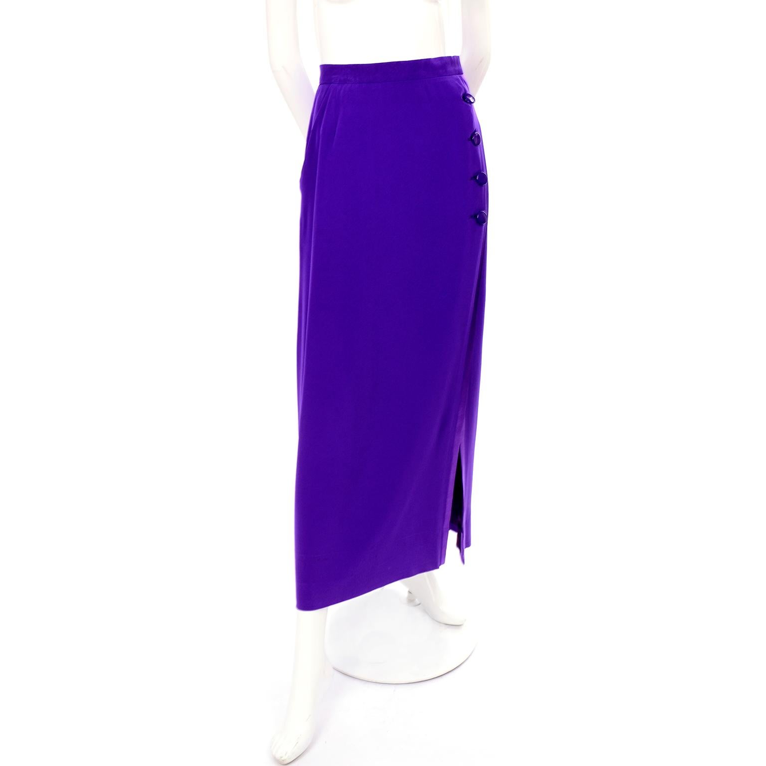 This is a wonderful Yves Saint Laurent Rive Gauche purple wool crepe skirt fully lined in dark purple satin. This lovely 1990's skirt has four purple button closures down the side, leading to a large open slit. It has one slit pocket on the right