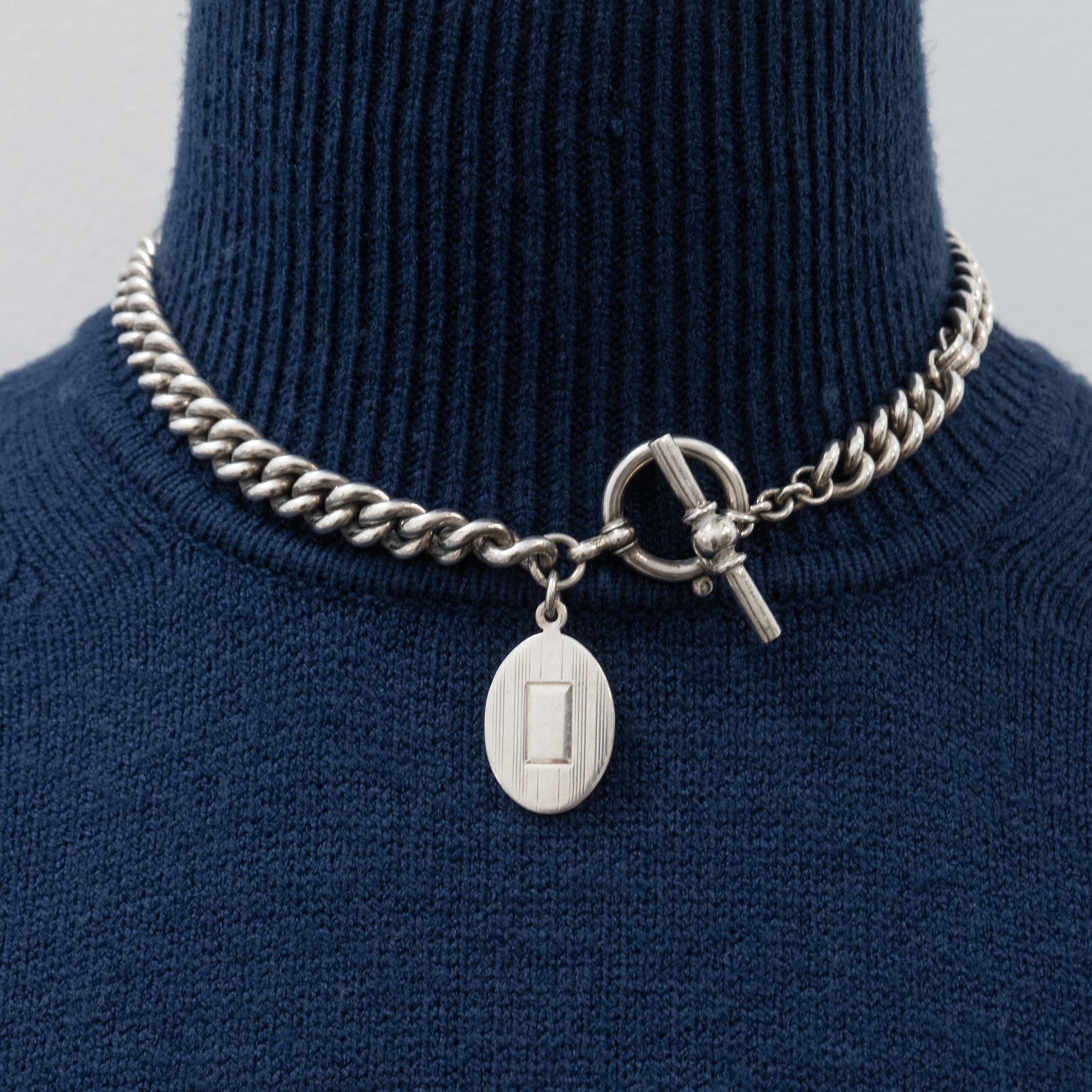 A timeless piece of Ralph Lauren Sterling Silver Chain Necklace also can be pocket watch chain with a oval silver tag and silver Toggle clasp weighs approximate 89.7 grams from 1990s

Approximate Measurement:
Necklace - 16 inches long
Oval Tag -