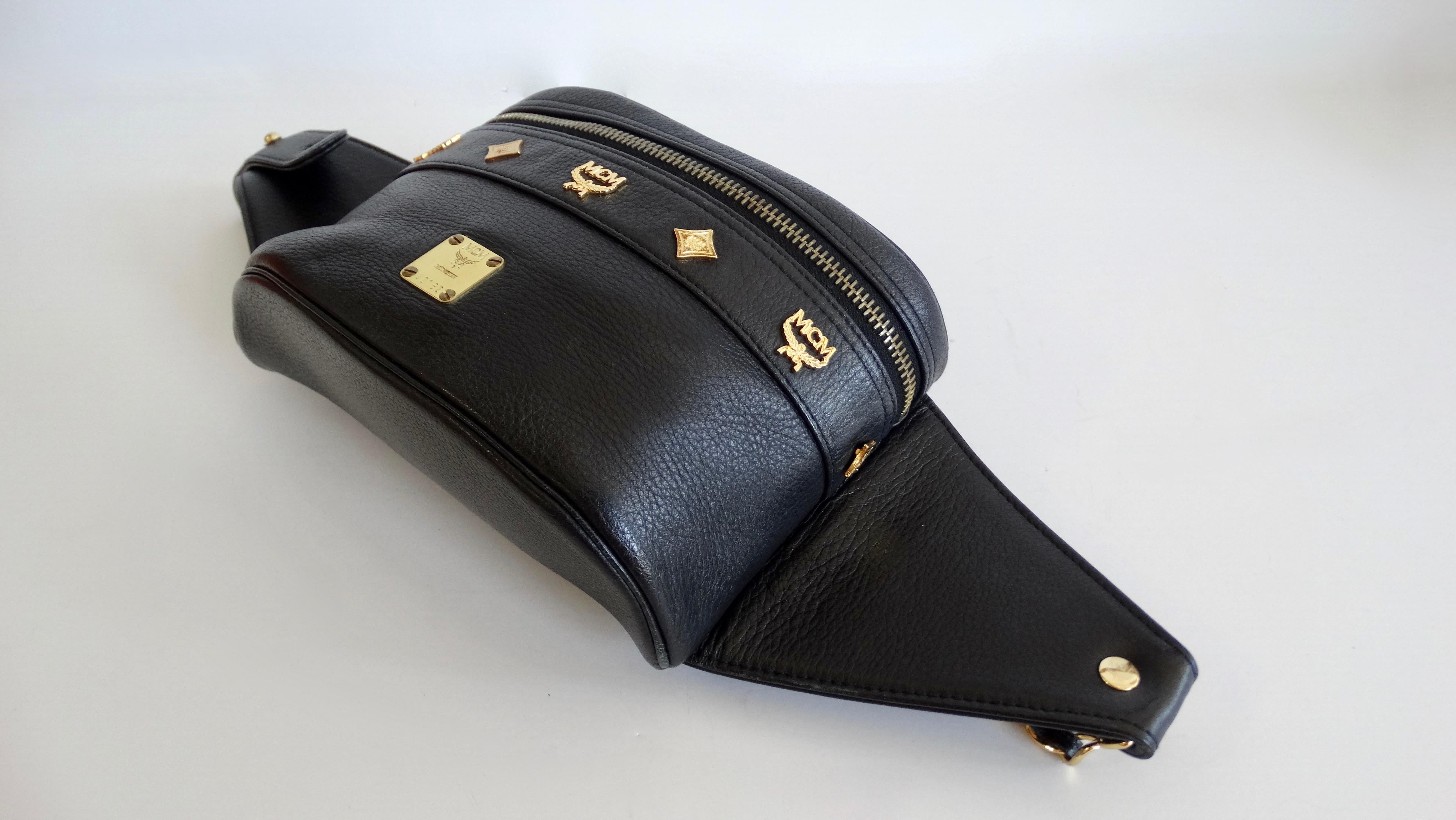 We will never be over a good fanny pack! Circa late 80s/ early 90s, this rare MCM fanny pack designed by Michael Cromer is made of black grained leather and features gold hardware. The front face is decorated with logo embossed studs and a small