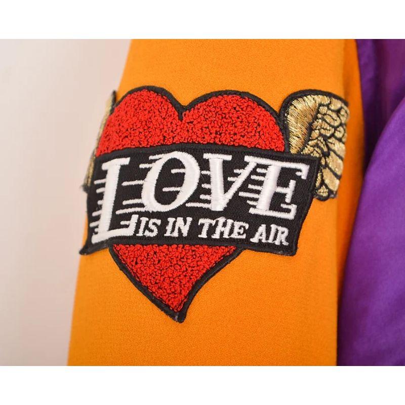 Superb, Colourful Vintage 1990's Moschino 'Cheap & Chic' Varsity jacket, featuring a purple satin body with orange sleeves and 'for your eyes only' embroidered detailing spelled out on the reverse.

MADE IN ITALY !

Features:
Central line zip