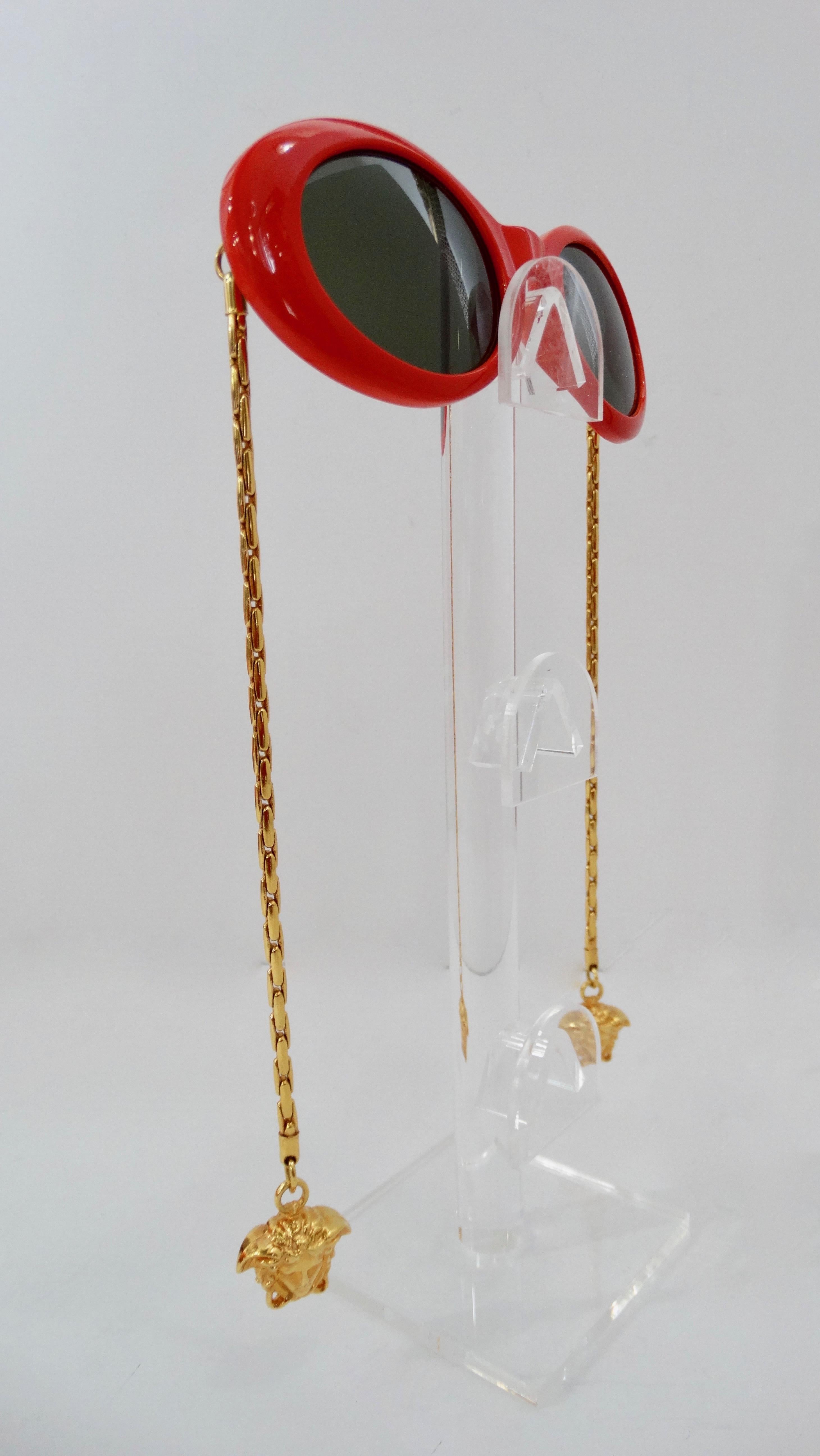 Need a showstopper? Well, these Versace sunnies are perfect! Circa 1990s, these oval sunglasses are a vibrant lipstick red color and include black lenses. Features gold chain arms with Medusa head charms. Don't miss out on this rare item! 