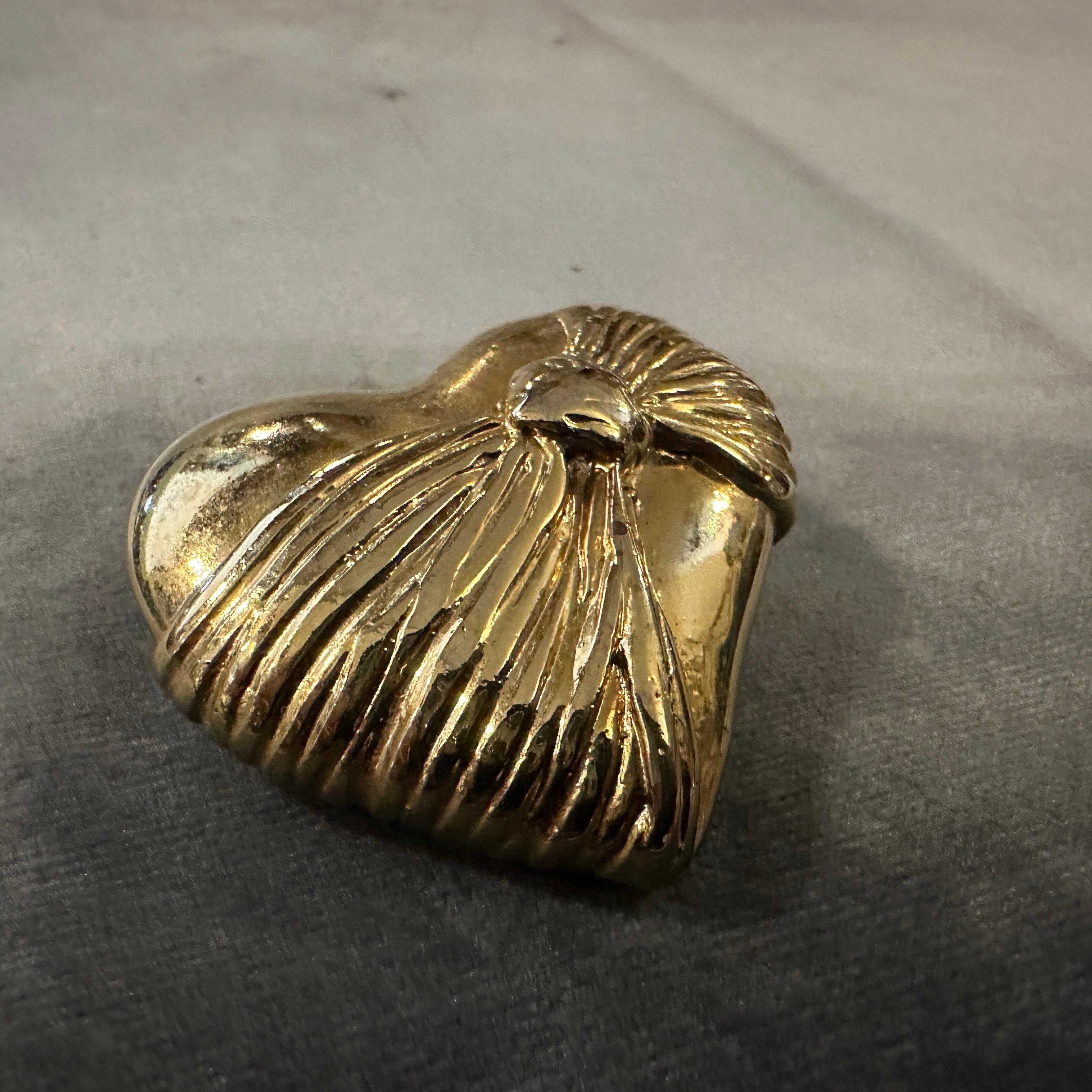 This is a stunning 1990s Retro Brass Heart Brooch by Loris Azzaro, the celebrated French designer known for his glamorous and bold jewelry designs.
Made from polished brass, giving it a rich golden tone with a vintage patina, it features a