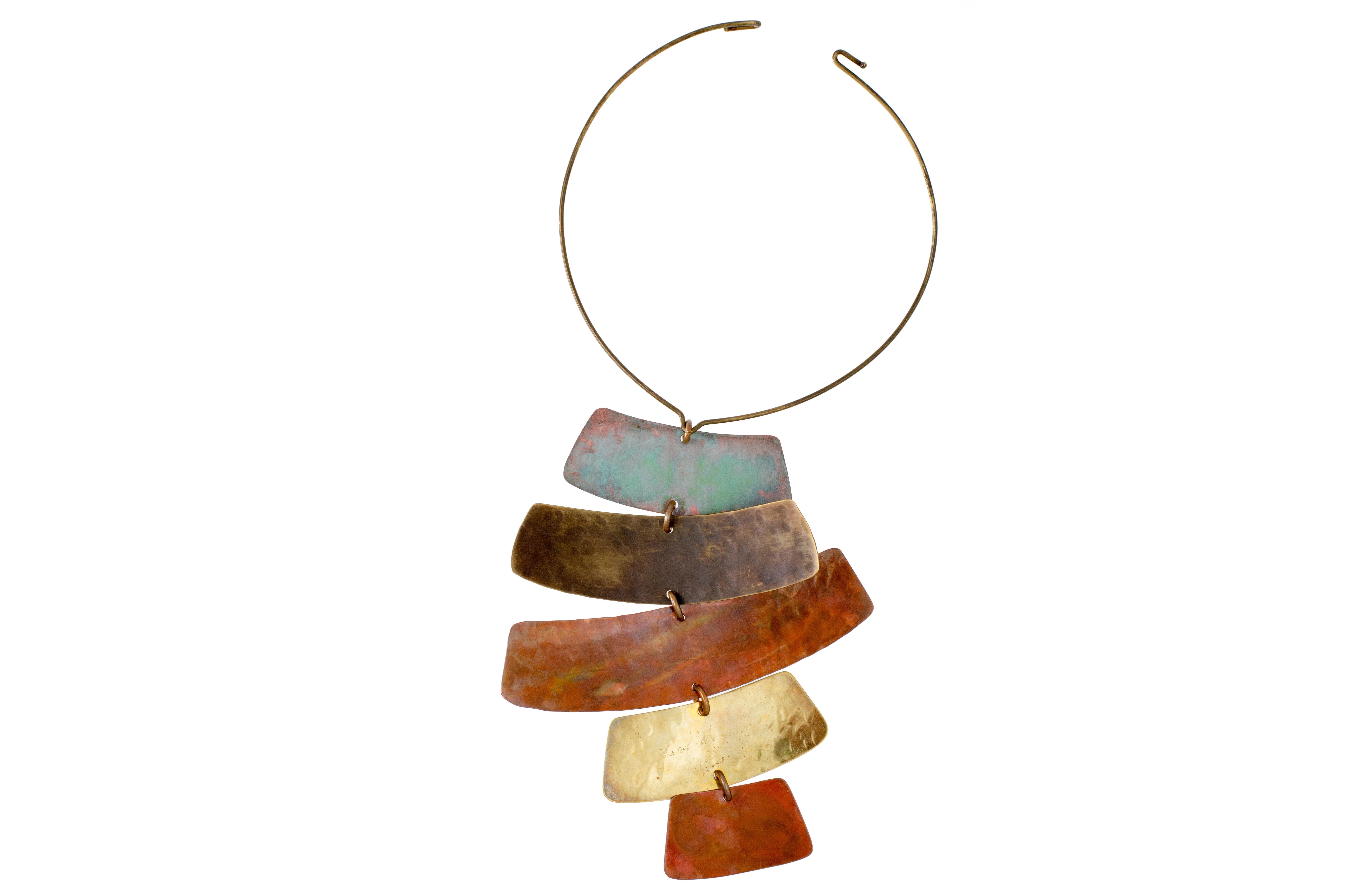 A patinated copper and brass totem necklace, by Robert Lee Morris , c. 1990s.
This necklace comes from his Mandala Collection, which was inspired by ancient jewelry and decorative objects. 
The pendant is 7