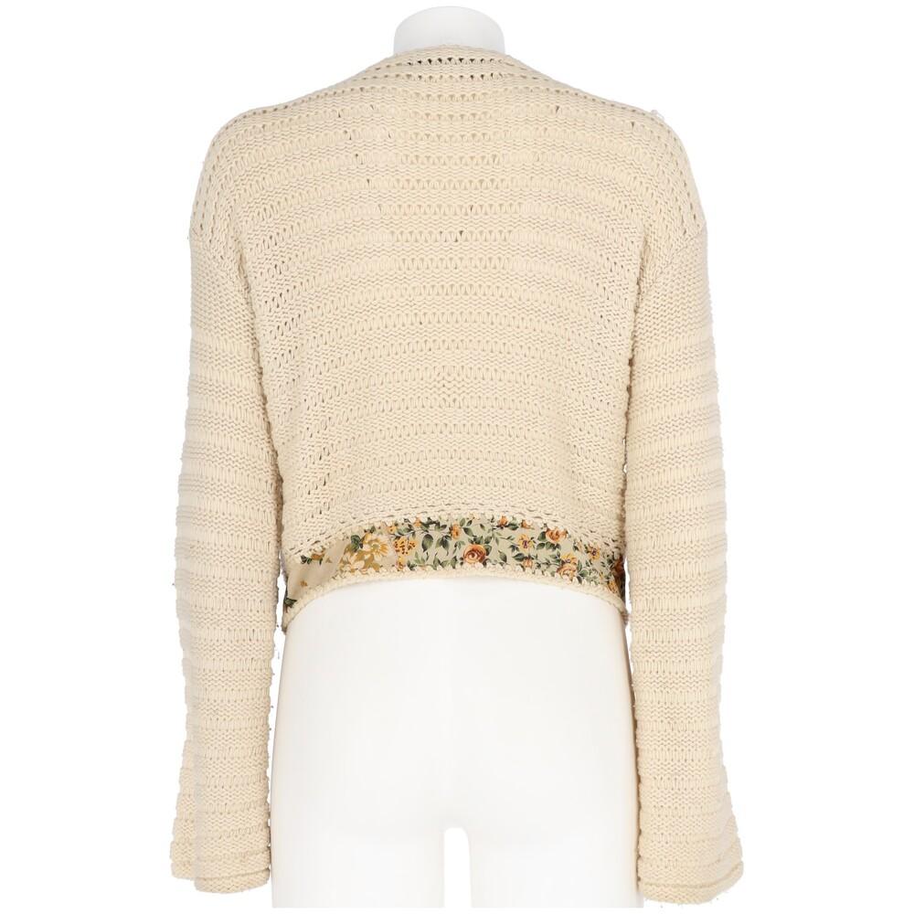 Roberto Cavalli wide-knit ivory wool, cashmere and silk blend cardigan. Model with V-neck, ribbed flared long sleeves, front knit decorations and covered buttons fastening. Suede leather insert on the bottom with print.
Item shows light signs of