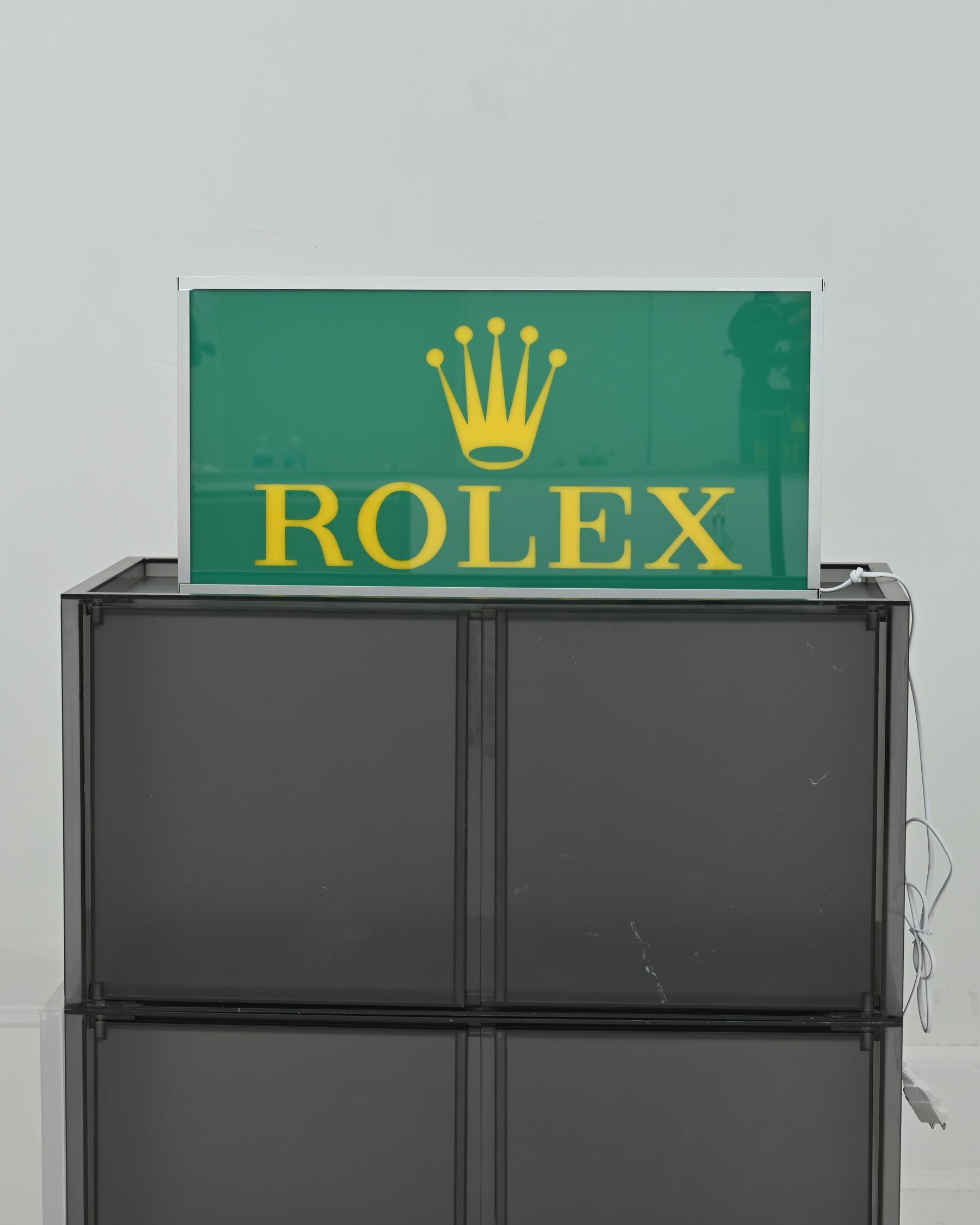 1990s ROLEX light board made of steel and plexiglass, with the Rolex logo and a protective plate. The sign has very minimal indications of use. The circuit board is made up of yellow LED lighting. Country of origin: Switzerland