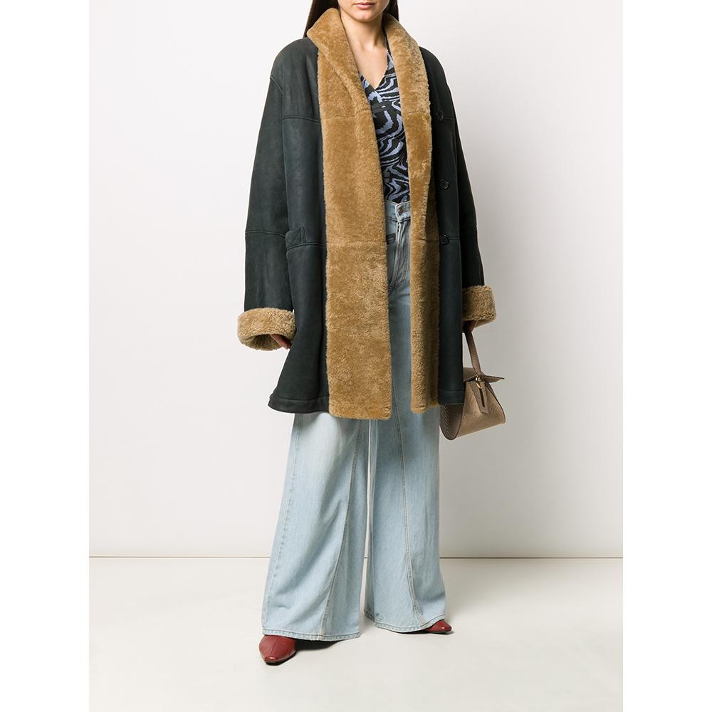 Romeo Gigli greyish dark blue sheepskin coat with beige fur. Featuring a front buttoning, long sleeves, two front pockets and central rear vent.

This item shows some signs of wear on the leather, as shown in the pictures.

Years: 90s

Made in