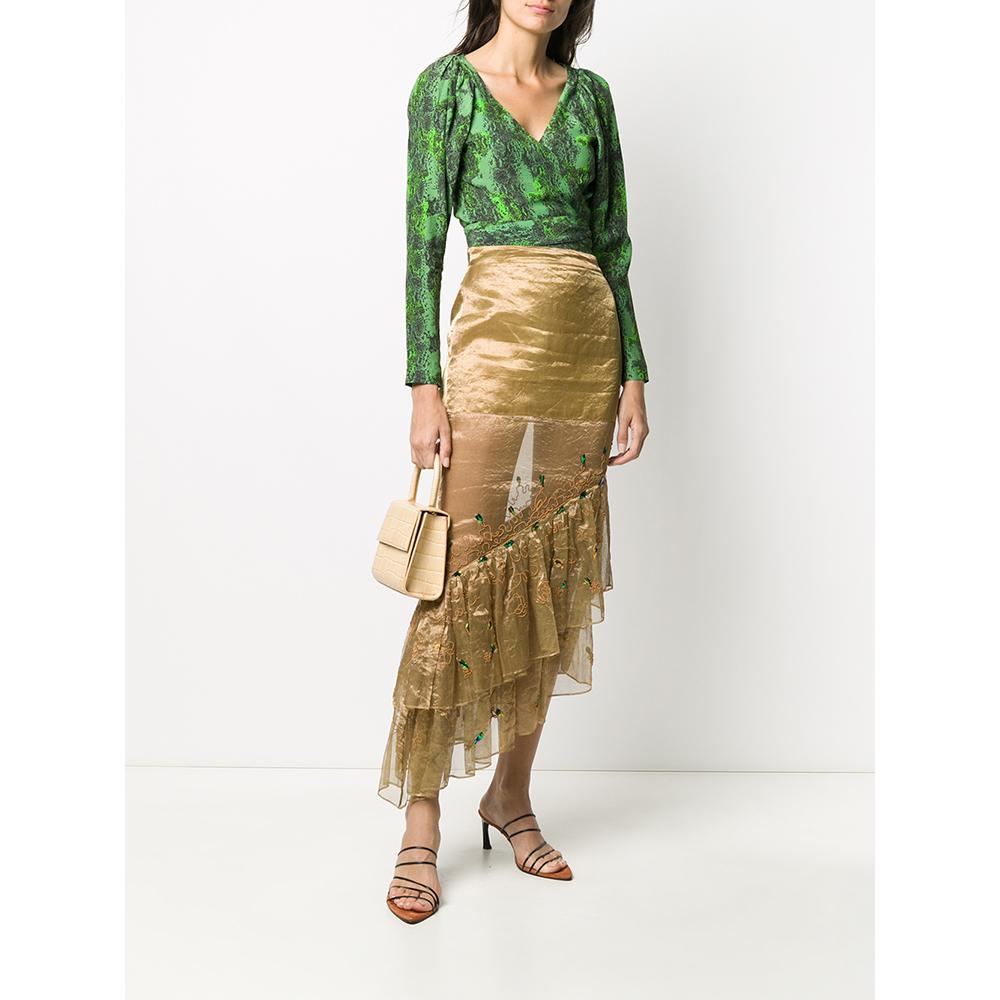 Romeo Gigli gold silk blend fabric skirt. Asymmetrical model with high waist, semi-transparent part and flounces on the bottom. Decorative stitching with iridescent blue applications. Side closure with zip and button.

Size: 42 IT

Flat