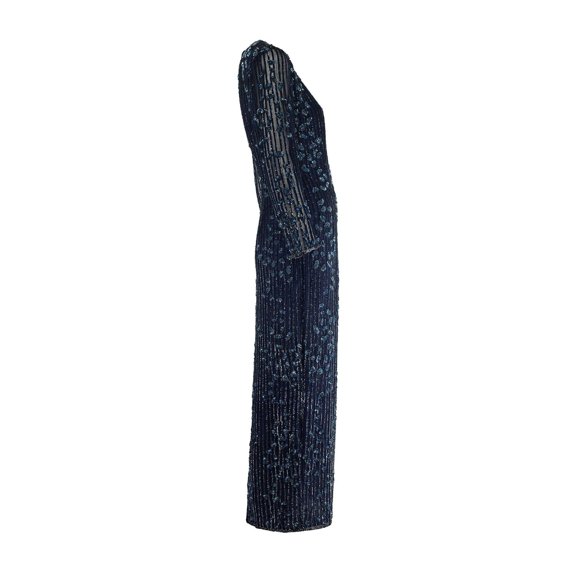 This late 1980s to early 1990s glittering sequinned maxi dress in navy blue is by the famous London boutique Roots. Sadly the boutique, which was located in fashionable Chelsea on the Kings Road, closed its doors sometime in the mid-1990s. It is