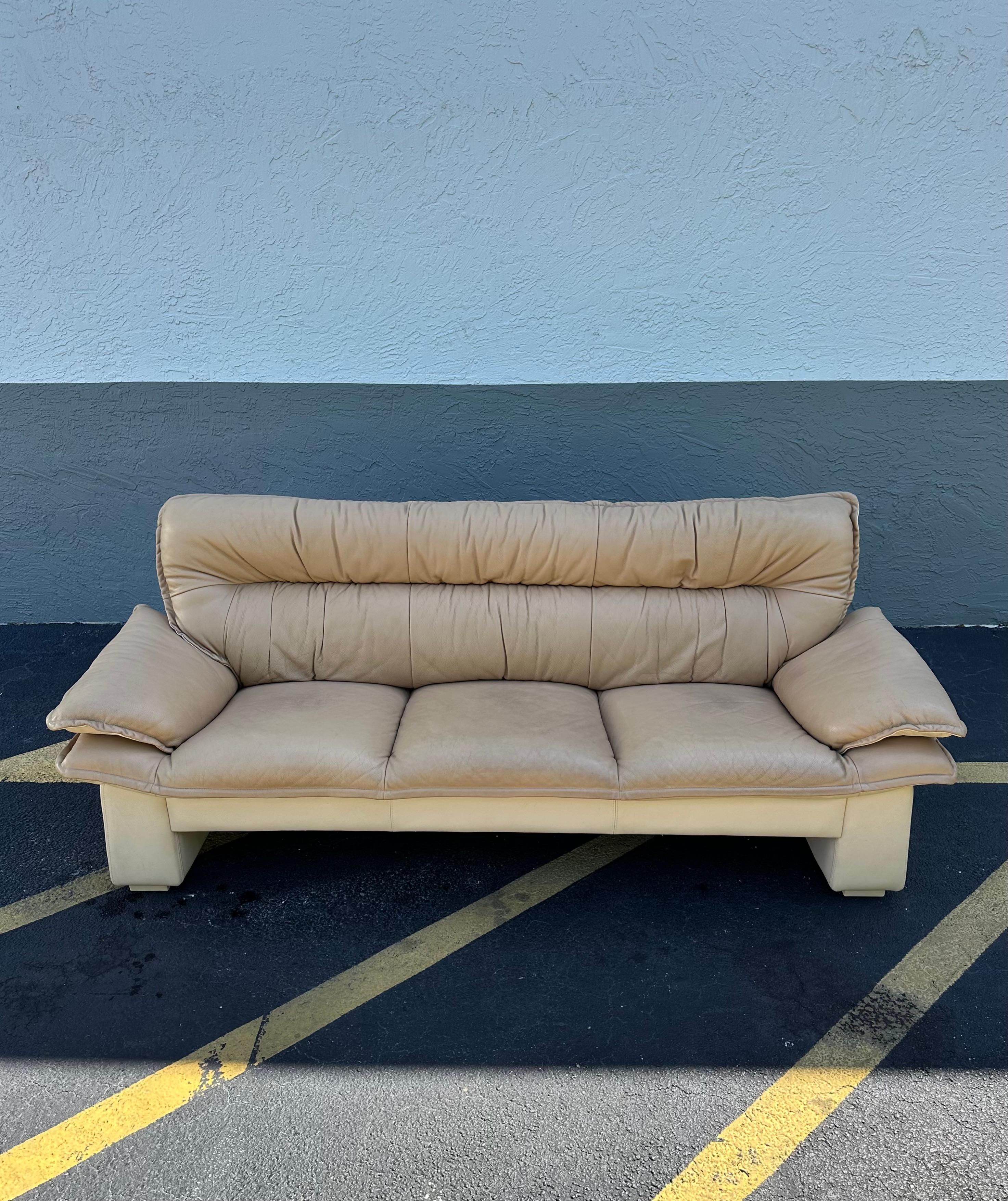 Versetzen Sie sich mit diesem exquisiten zweifarbigen beigen Ledersofa in die eleganten und anspruchsvollen 1990er Jahre zurück. Das äußerst seltene Dreisitzer-Sofa strahlt einen Hauch von Luxus und Raffinesse aus. Das Design ist durchgängig