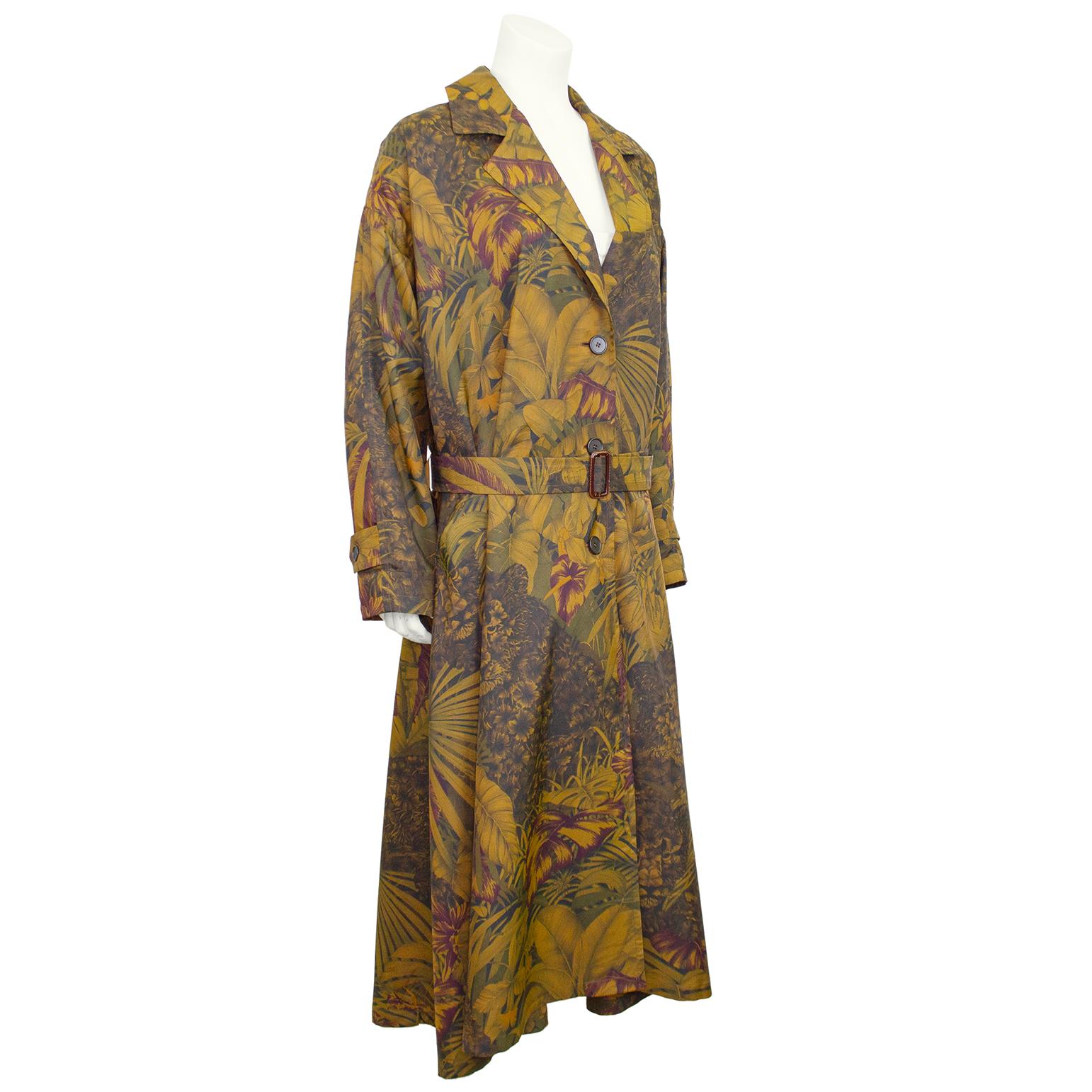 Manteau trench noir et bronze imprimé de feuilles de palmier Salvatore Ferragamo des années 1990. Design/One classique avec une coupe surdimensionnée ; col cranté, épaule tombante, manches chauve-souris, ceinture ajustable, poignets à boucle et