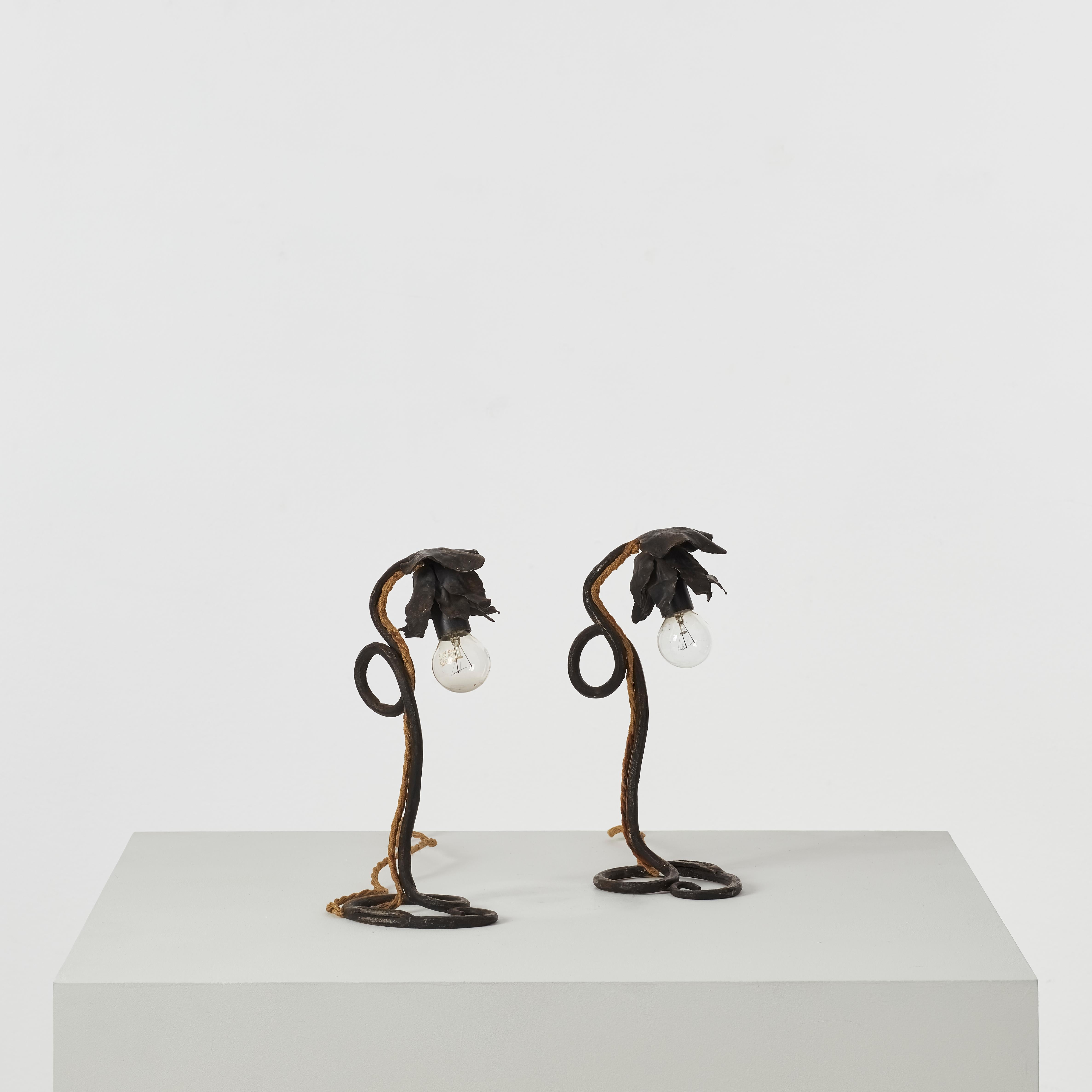 Paire de lampes de table assorties. Les pétales délicats des pièces captent la lumière avec une texture subtile, tandis que les bases Looping ancrent les œuvres avec un geste assuré.

La signature de l'artiste est gravée au bas de chaque lampe. Ils