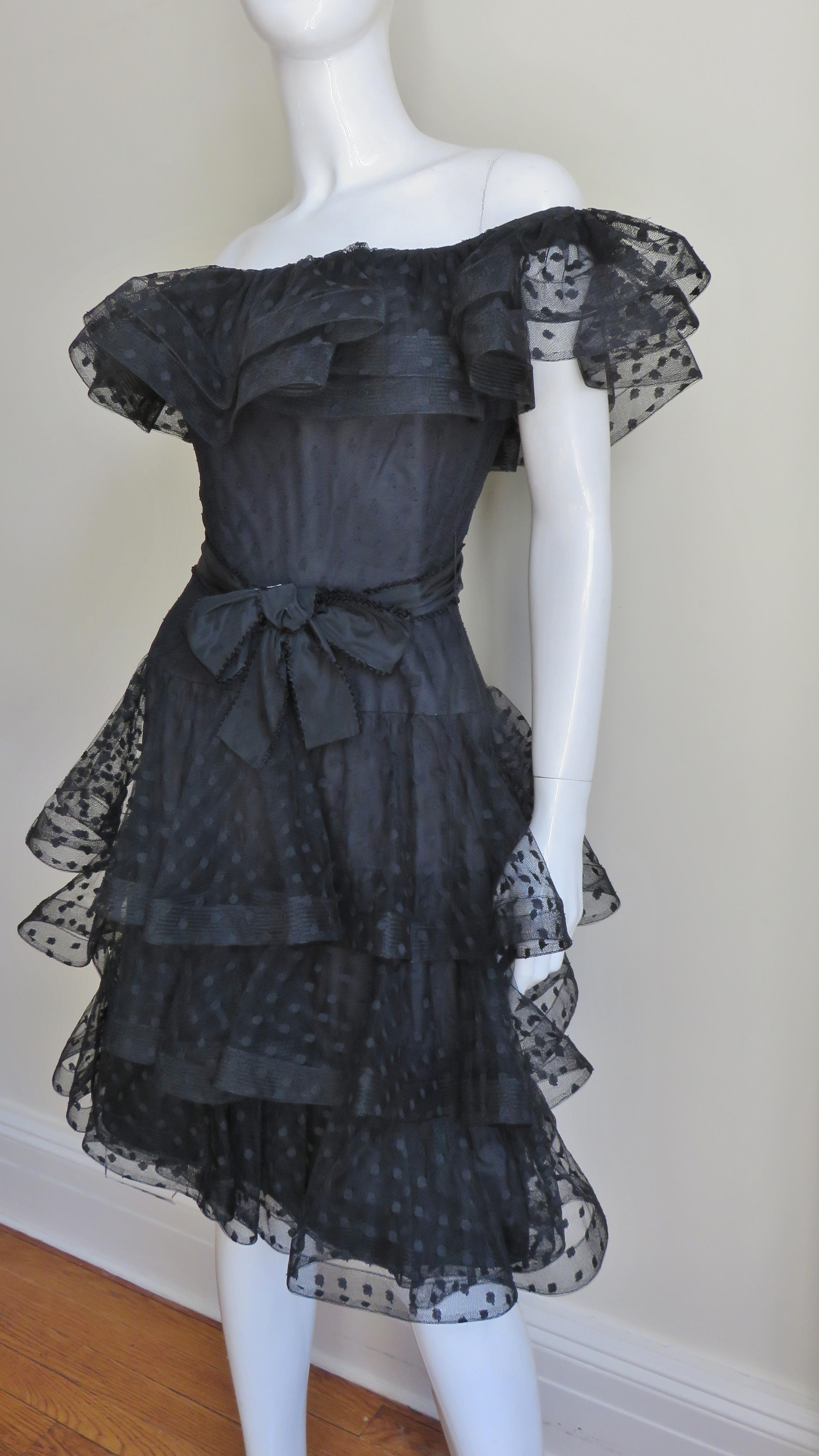 A fabulous black silk ruffle dress by Arnold Scassi.  It is made of black dot flocked silk tulle In ruffled layers around the shoulders and 3 tiered layers creating the skirt.  There is stiffening at their edges giving a them a nice fullness.  It is