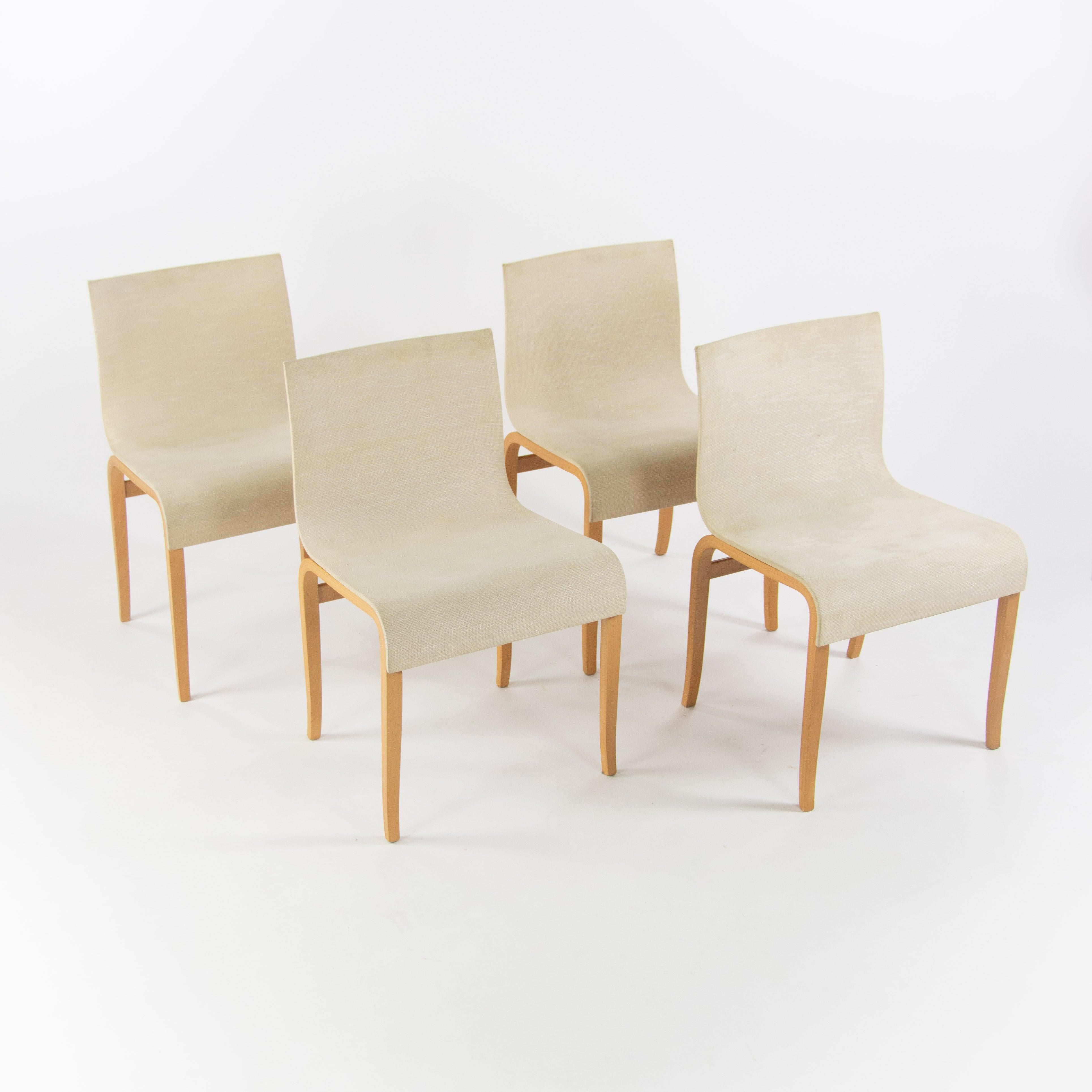 Listed for sale is a set of four gorgeousGina / Ginotta bent plywood dining chairs with oatmeal-color fabric upholstery, produced by Crassevig, distributed by Knoll in the US, and designed by Enrico Franzolini. The chairs are very good vintage