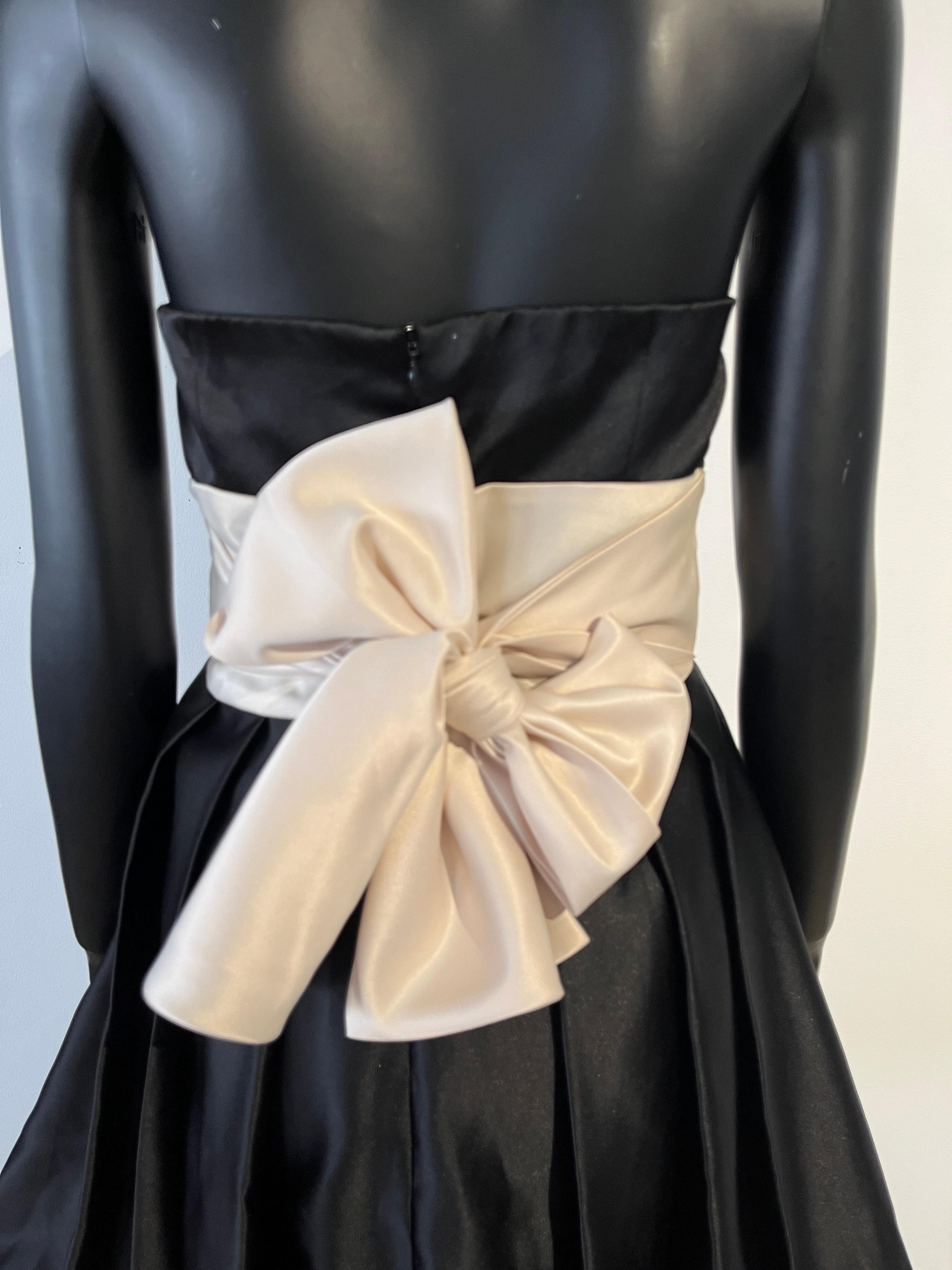 1990s strapless Silk Party Dress with Bow and Bubble Hemline in classic black and ivory. 
Waist ties can be tied in various ways. 
Size medium but would fit small.
Silk satin and fully lined. 
Zip closure and boned. 
Designed by Daniel Yam. 
The