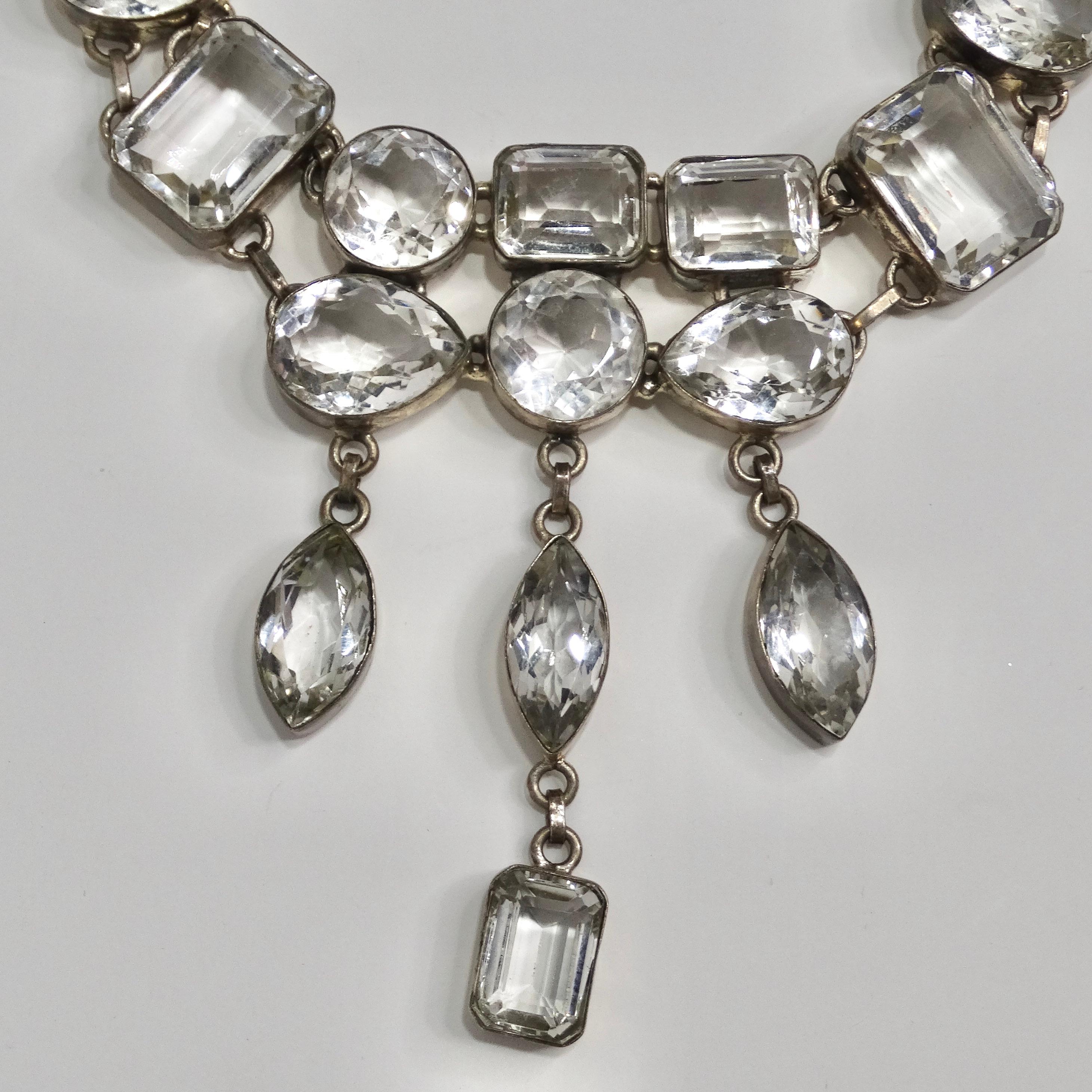 Elevate your style with this mesmerizing statement necklace that encapsulates the essence of the 1990s. Crafted with exquisite attention to detail, this necklace showcases an arrangement of large, clear crystals encased in silver settings. What