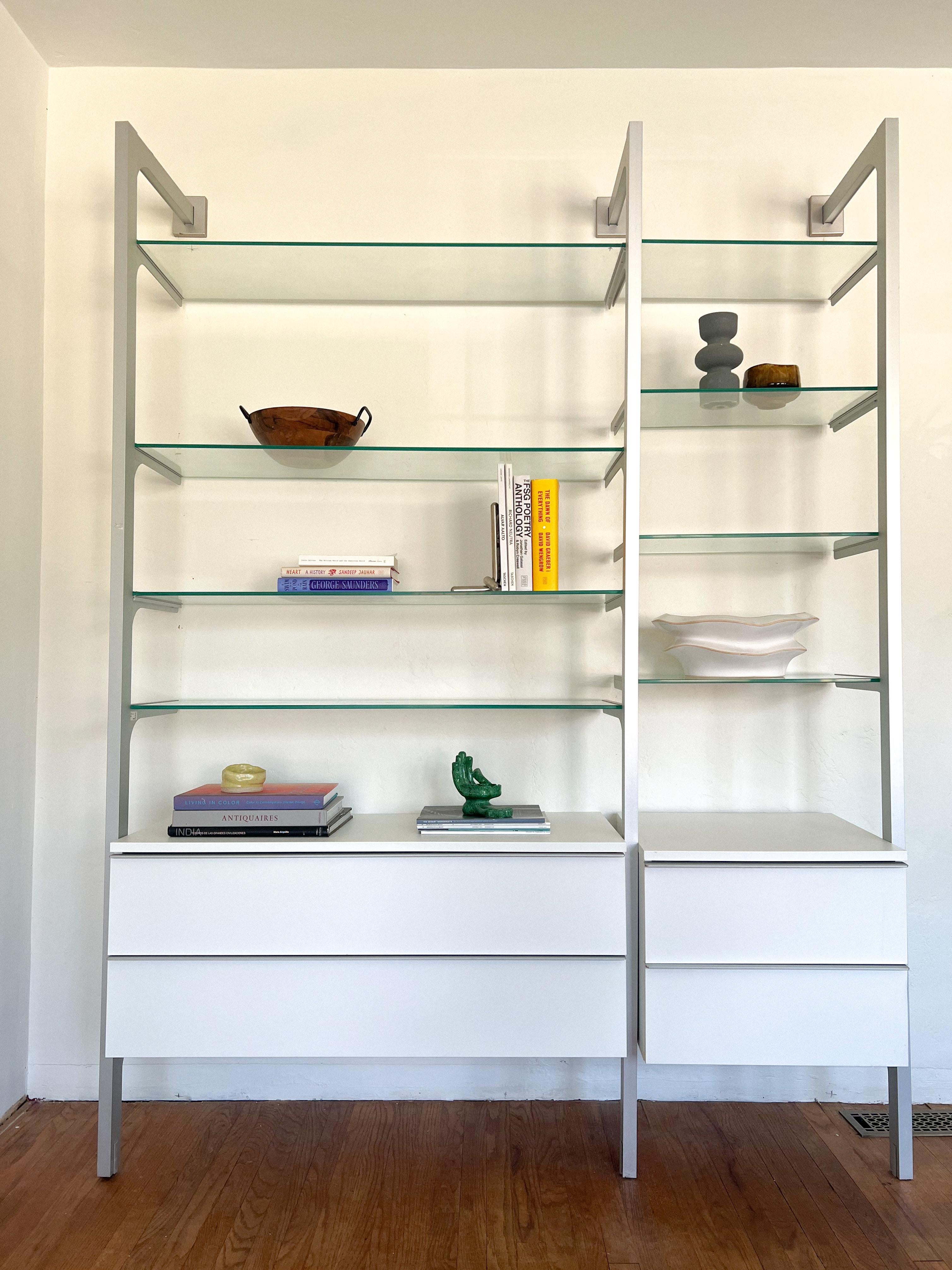This vintage wall shelving unit, reminiscent of Calligaris’ 1970s designs, features 12” deep tempered glass shelves with aluminum frames and brackets. 

The modular design allows for versatile arrangements, including two sets of spacious drawers.