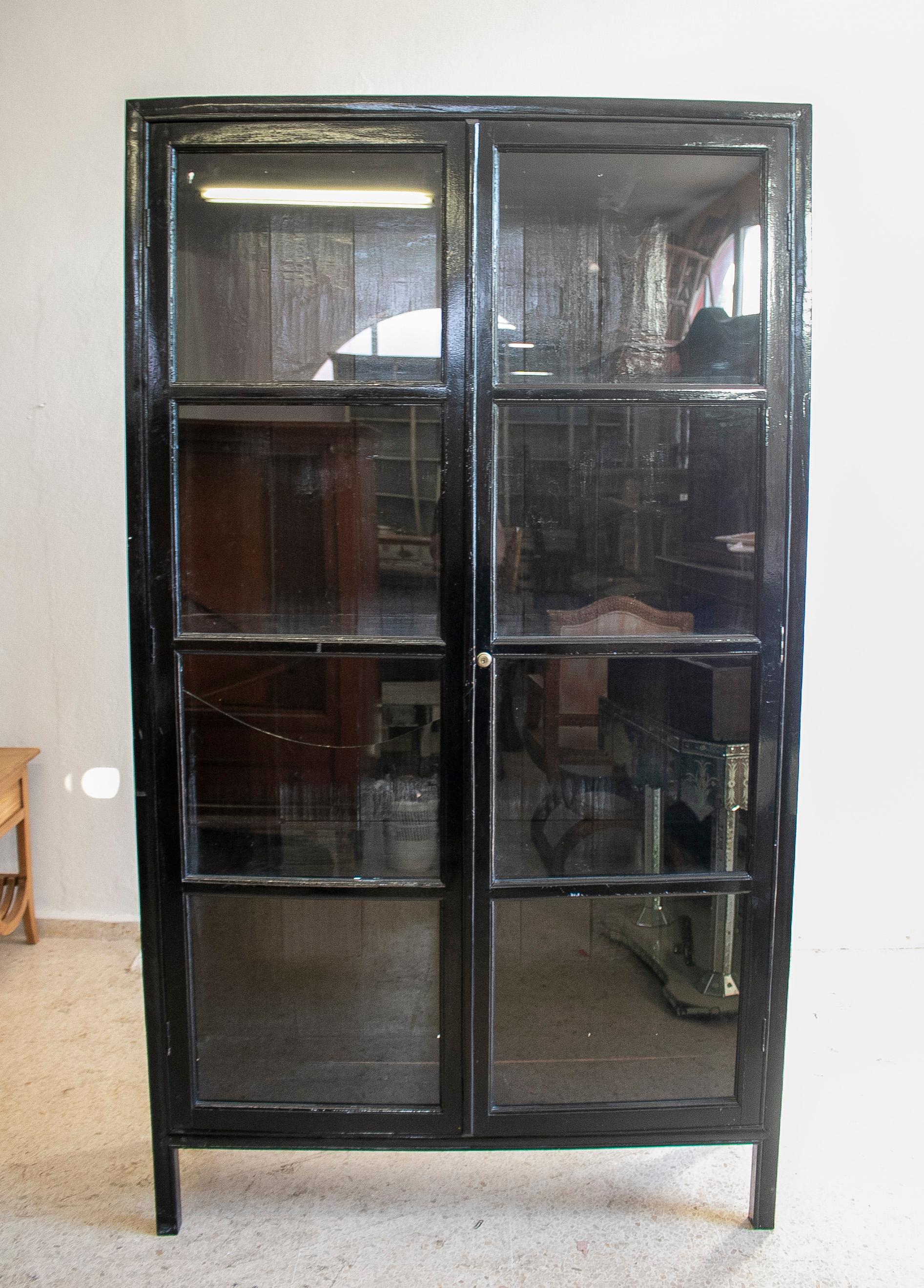 1990s Spanish 4-shelf black lacquered wooden glass cabinet.