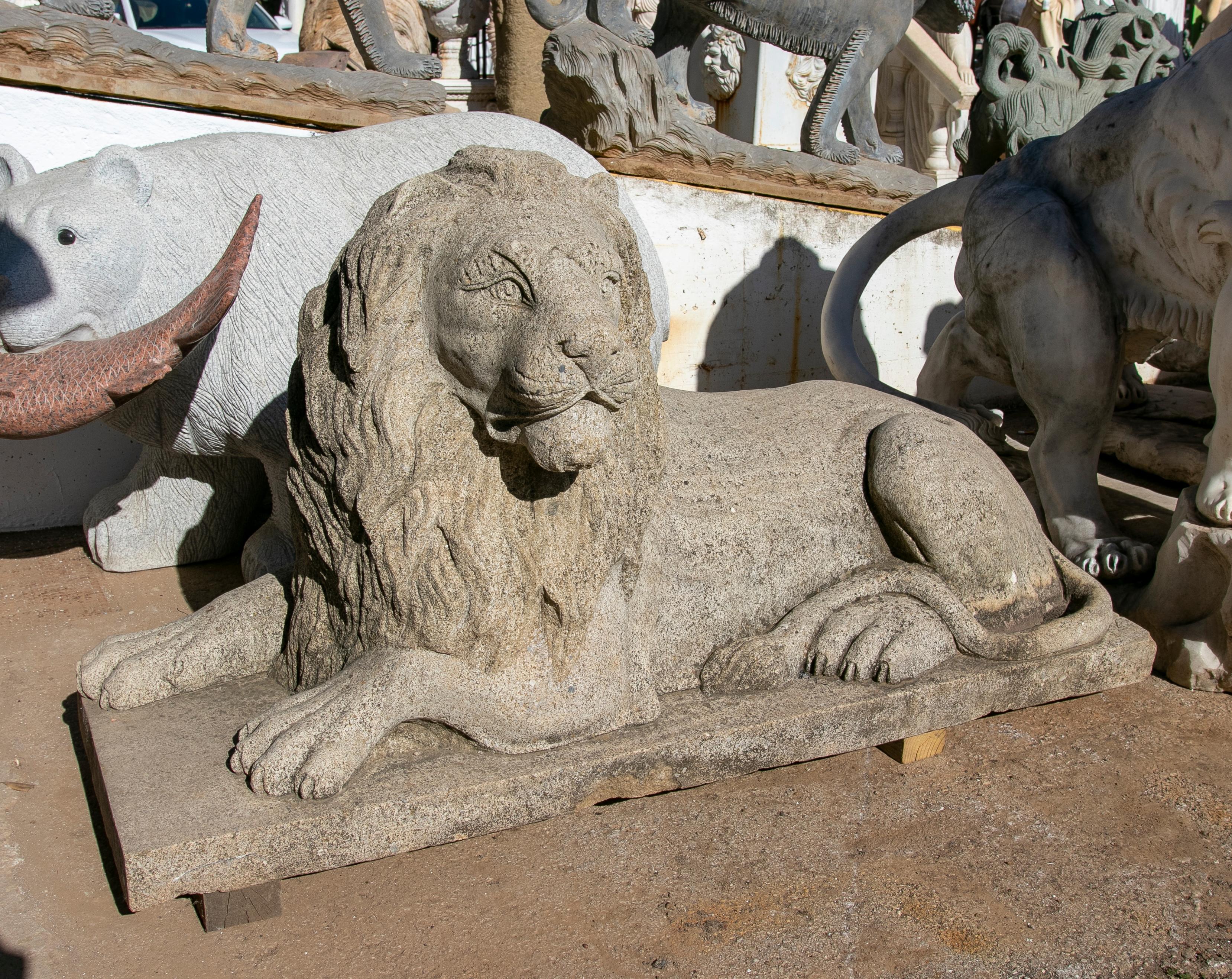 1990s Hand carved grey sandstone lying lion sculpture.